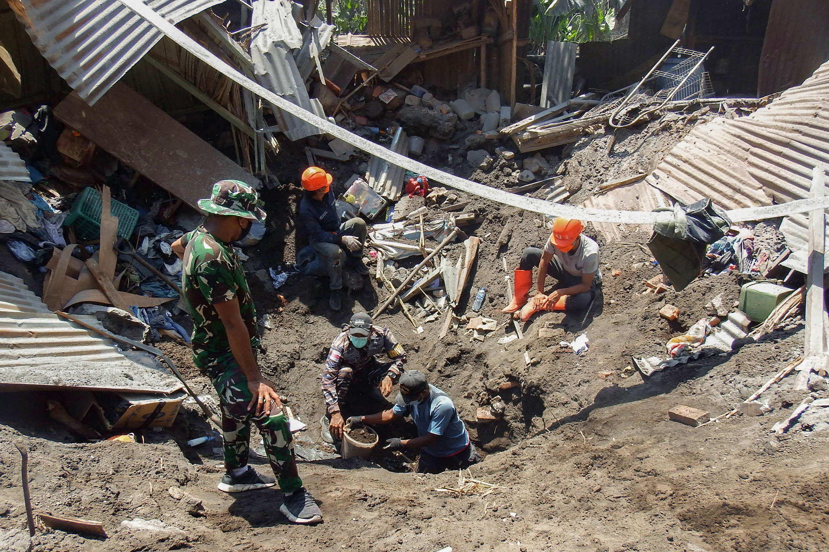 Members of a rescue team search for victims at Klatanlo village, in East Flores Regency, East Nusa Tenggara