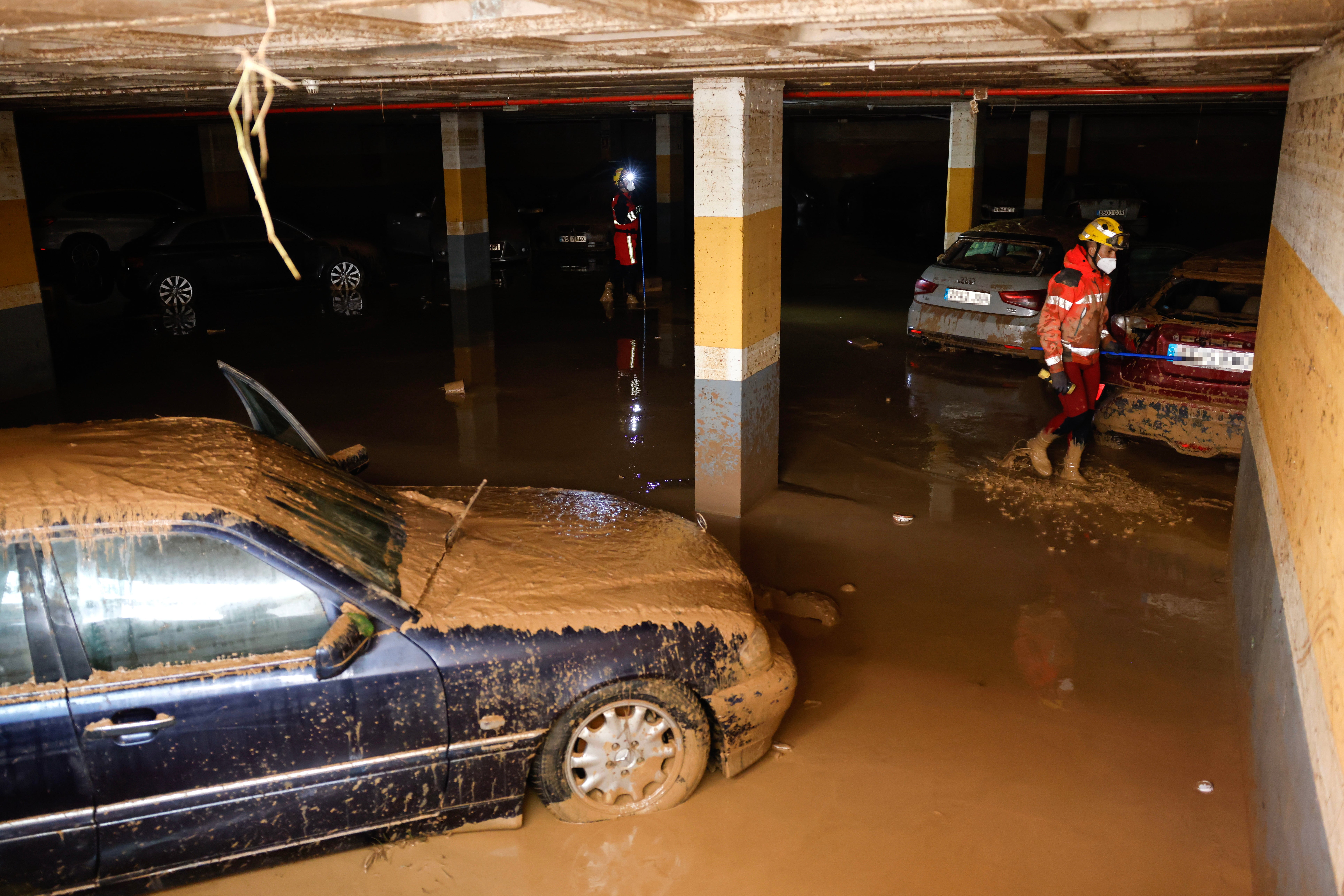 Firefighters search for victims at an underground parking lot following last week’s floods in the municipality of Sedavi