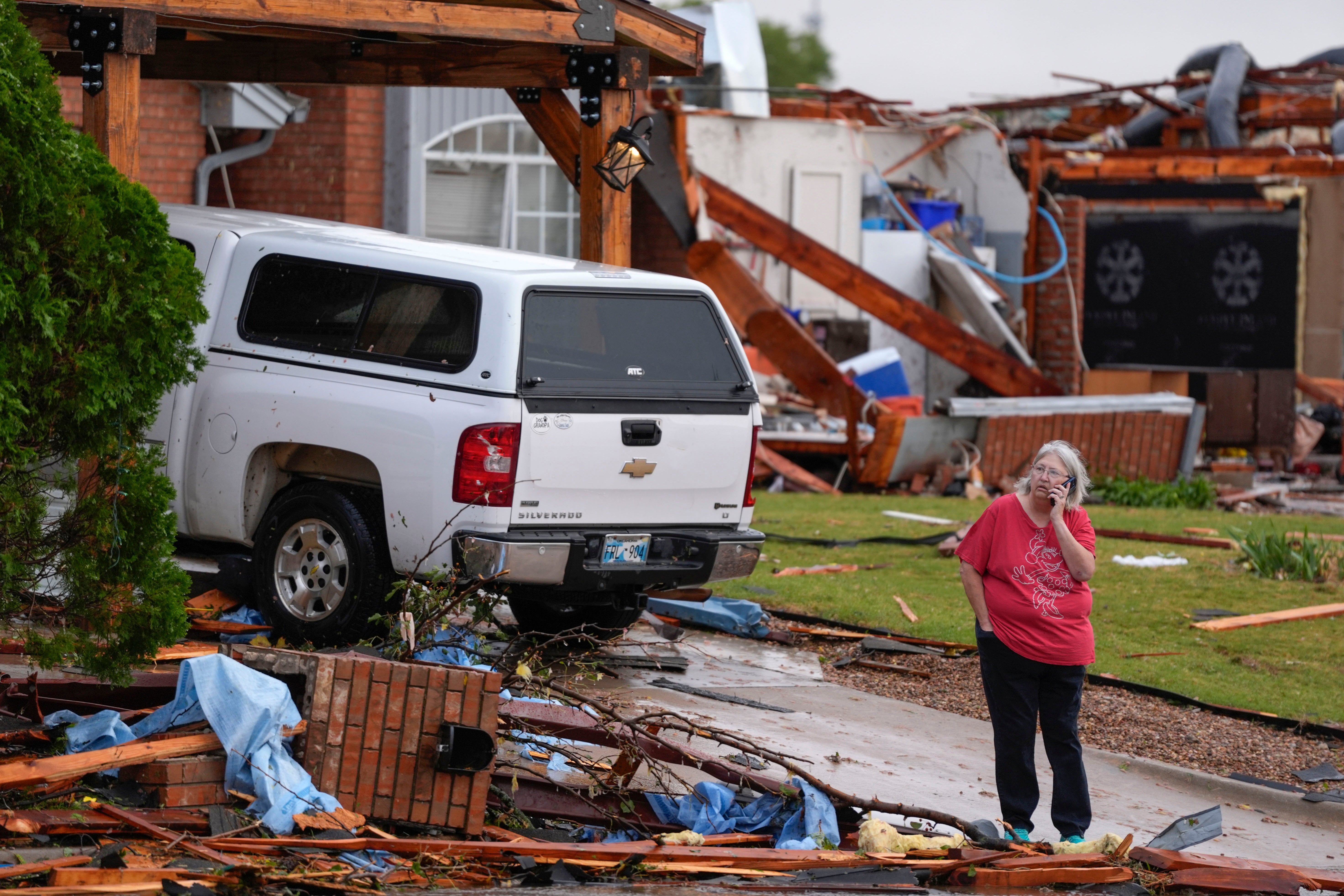 A woman stands outside a damaged home after a tornado in Oklahoma City, Oklahoma, on Sunday. More than 18,000 Oklahoma customers were left without power on Monday, with more storms expected to hit the area.