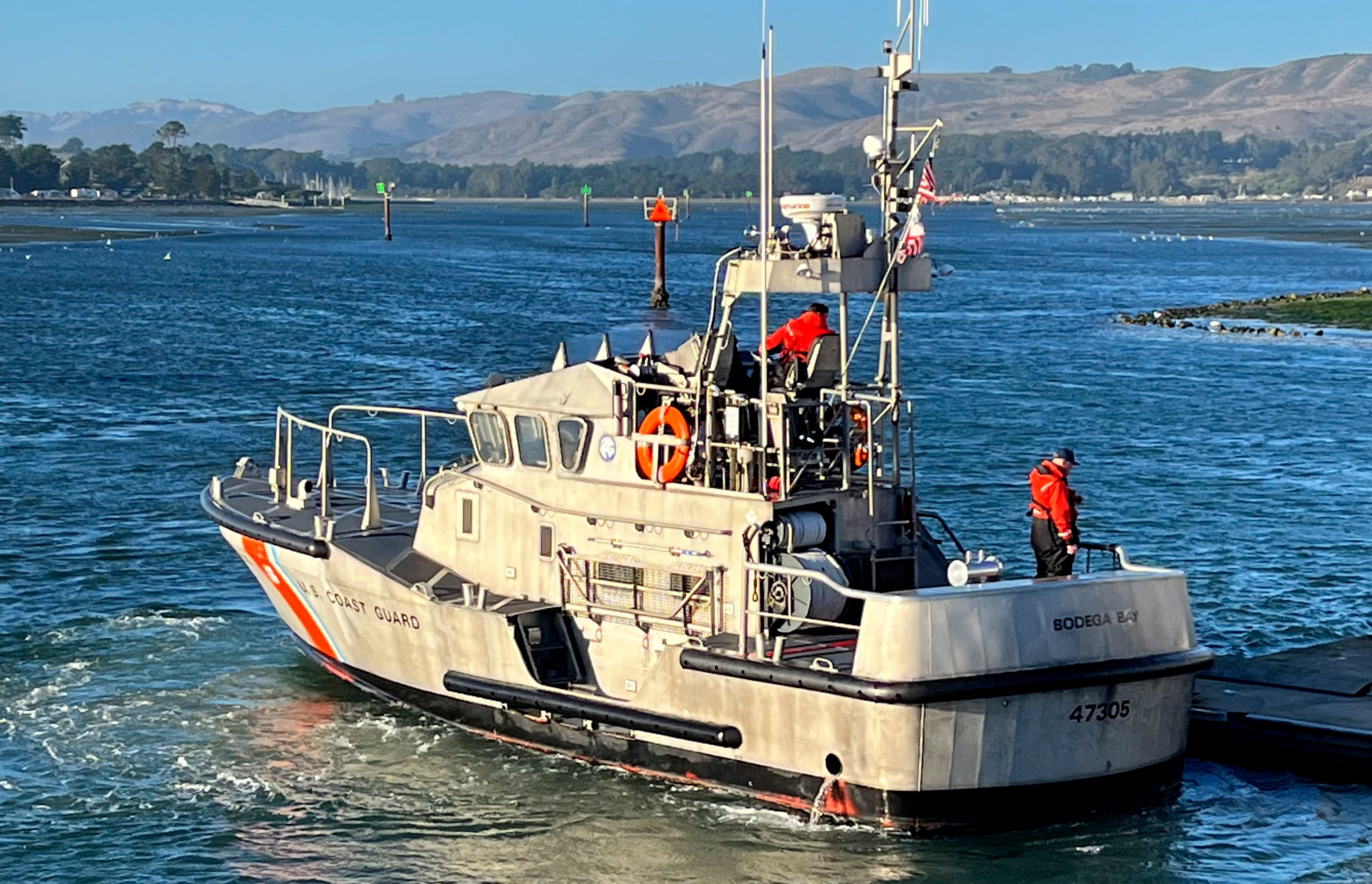 A US Coast Guard crew moors a boat to a pier in Bodega Bay, California, on Sunday. The Coast Guard later suspended its search for four missing boaters.