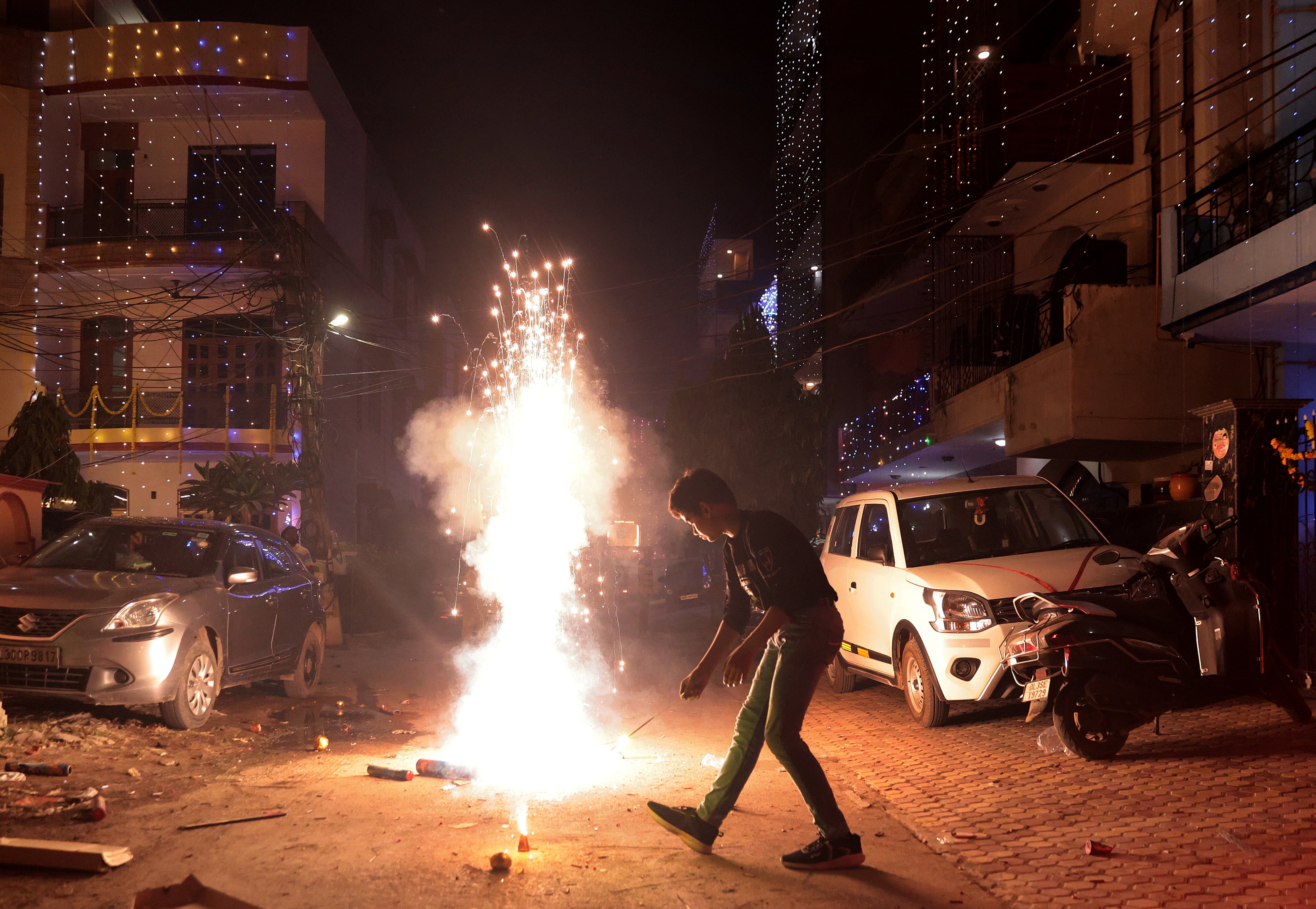 A boy lights paper fireworks on the occasion of Diwali, the Hindu festival of lights, in the outskirts of Delhi, India, 31 October 2024.