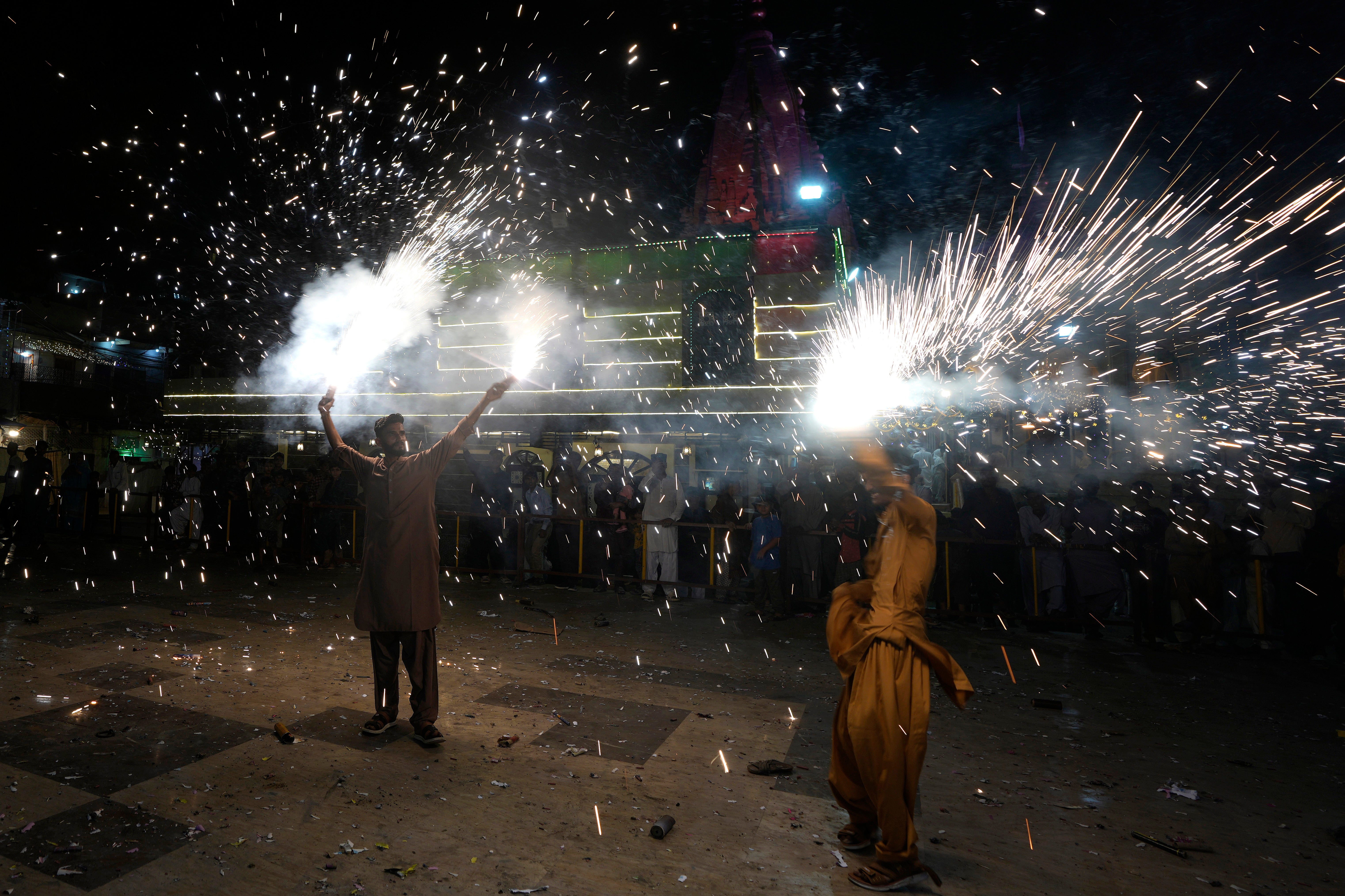 Representative: People hold fireworks at a ceremony to celebrate Diwali