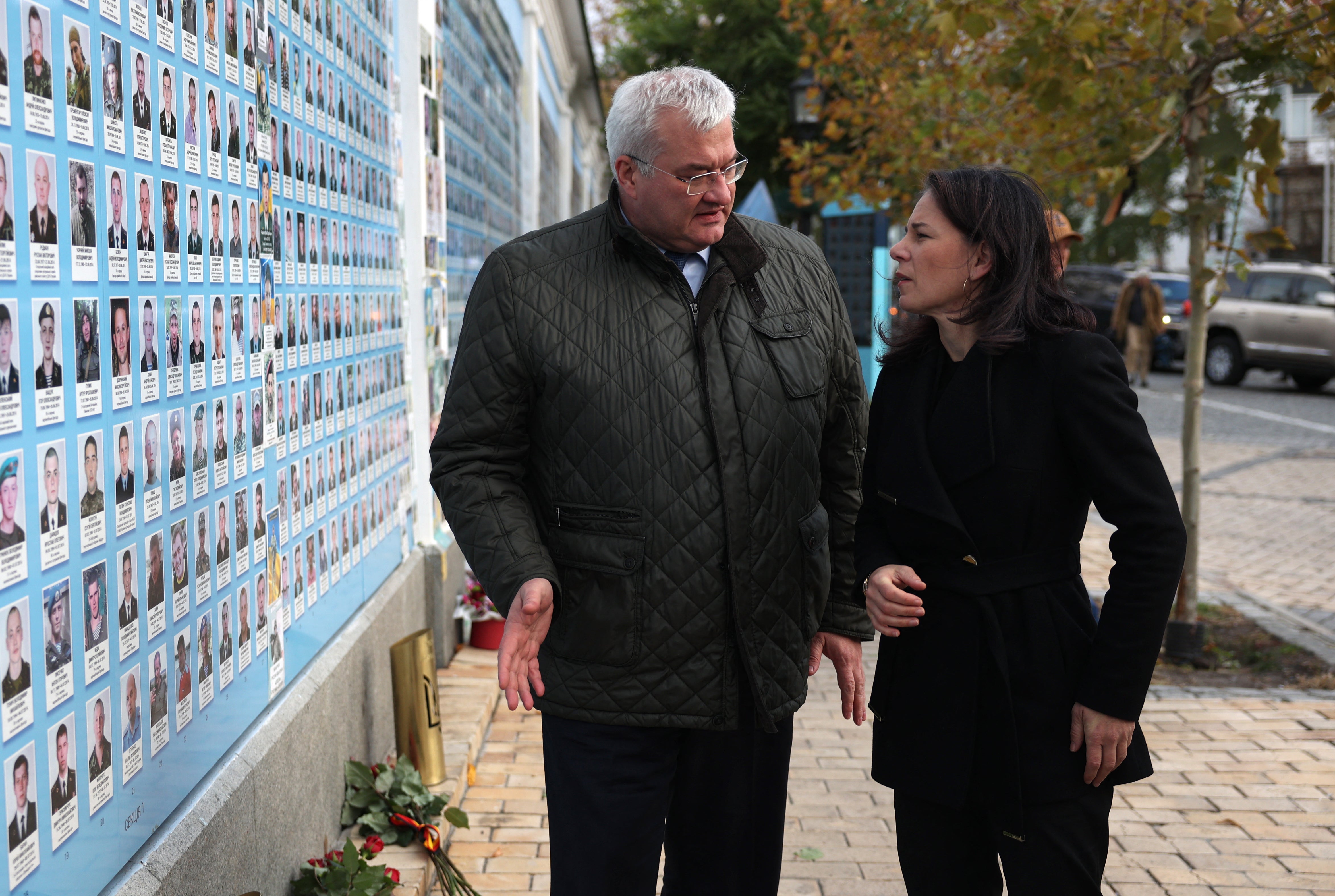 German foreign minister Annalena Baerbock and Ukrainian foreign minister Andrii Sybiha talk as they leave after a flower laying ceremony at the Memory Wall of Fallen Defenders of Ukraine outside Saint Michael’s Cathedral in Kyiv