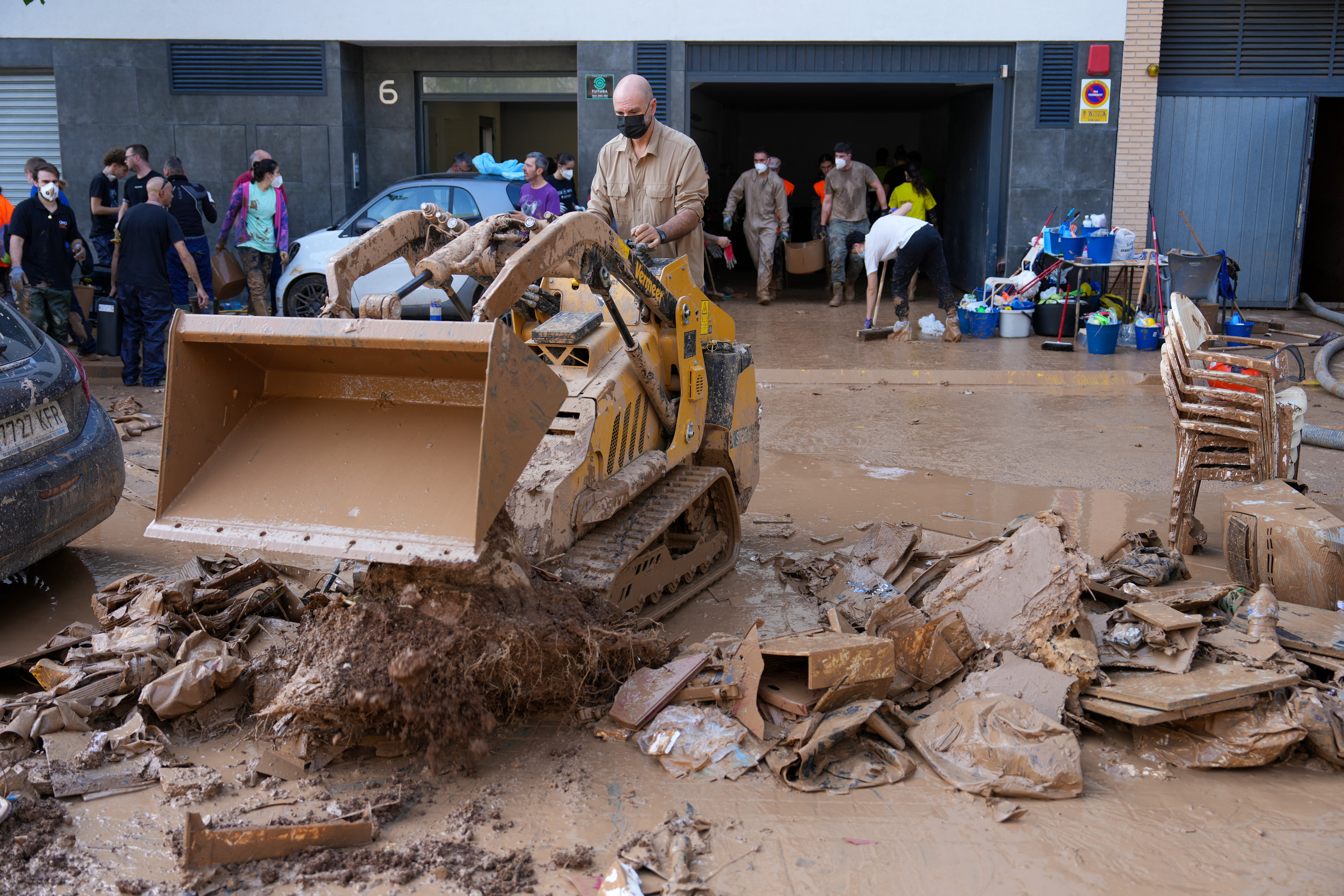 People clear mud and debris from a garage in Aldaia, in the region of Valencia, eastern Spain, on November 5