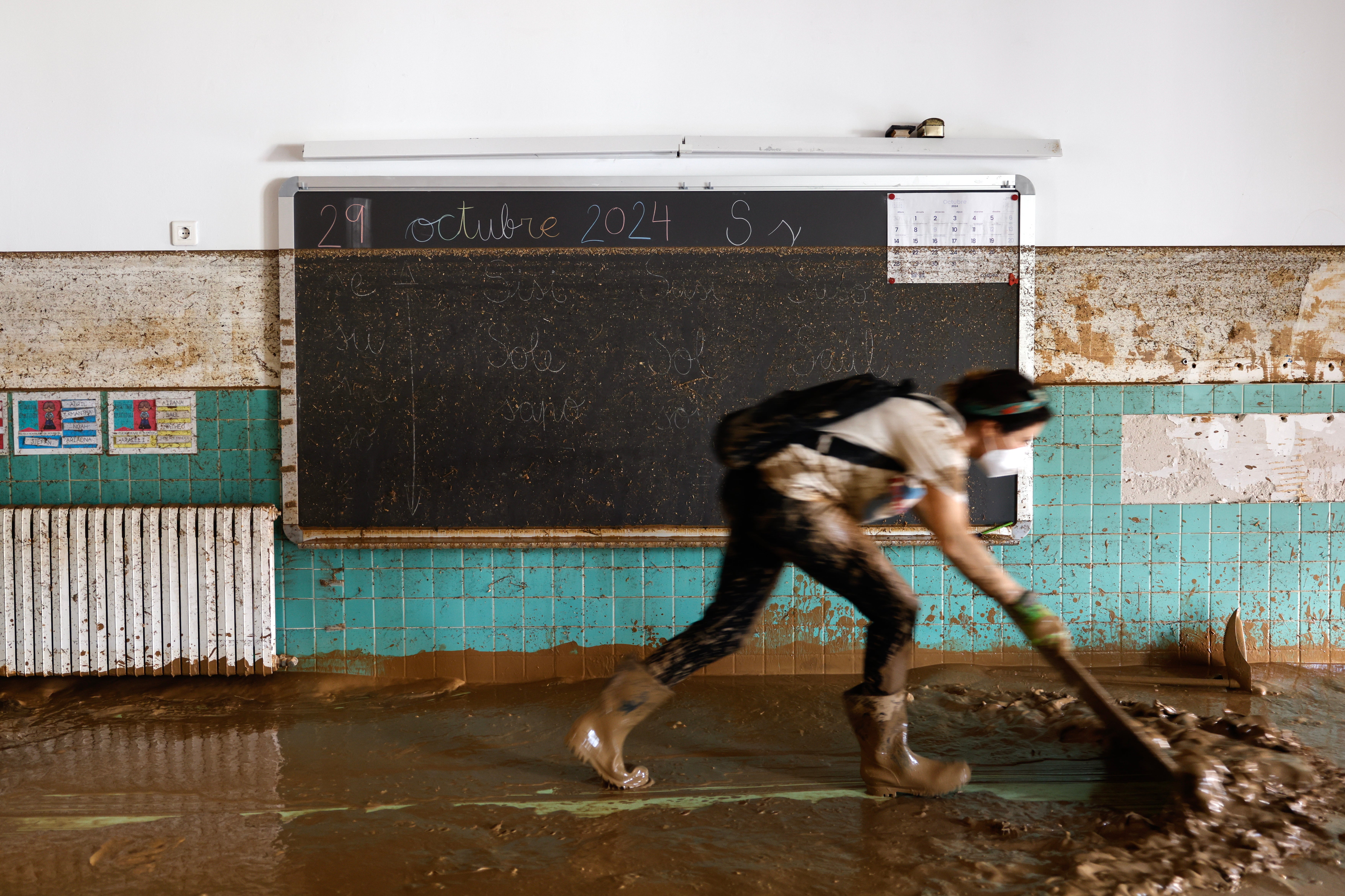 A woman clears mud from the floor of a flooded school in the municipality of Sedavi, province of Valencia, Spain, 04 November 2024