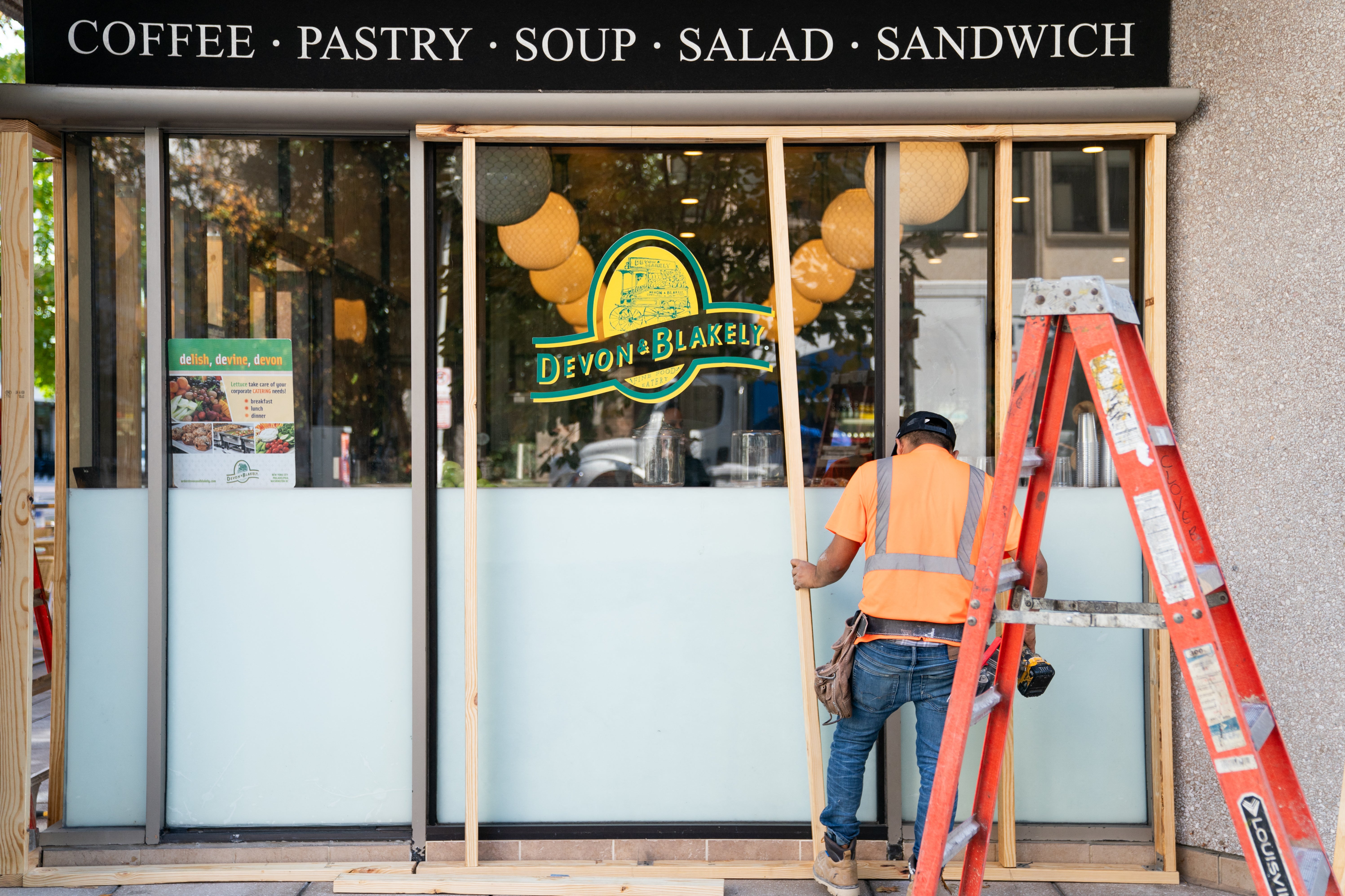 Workers board up a Devon and Blakely location near the White House, in Washington DC ahead of the presidential election