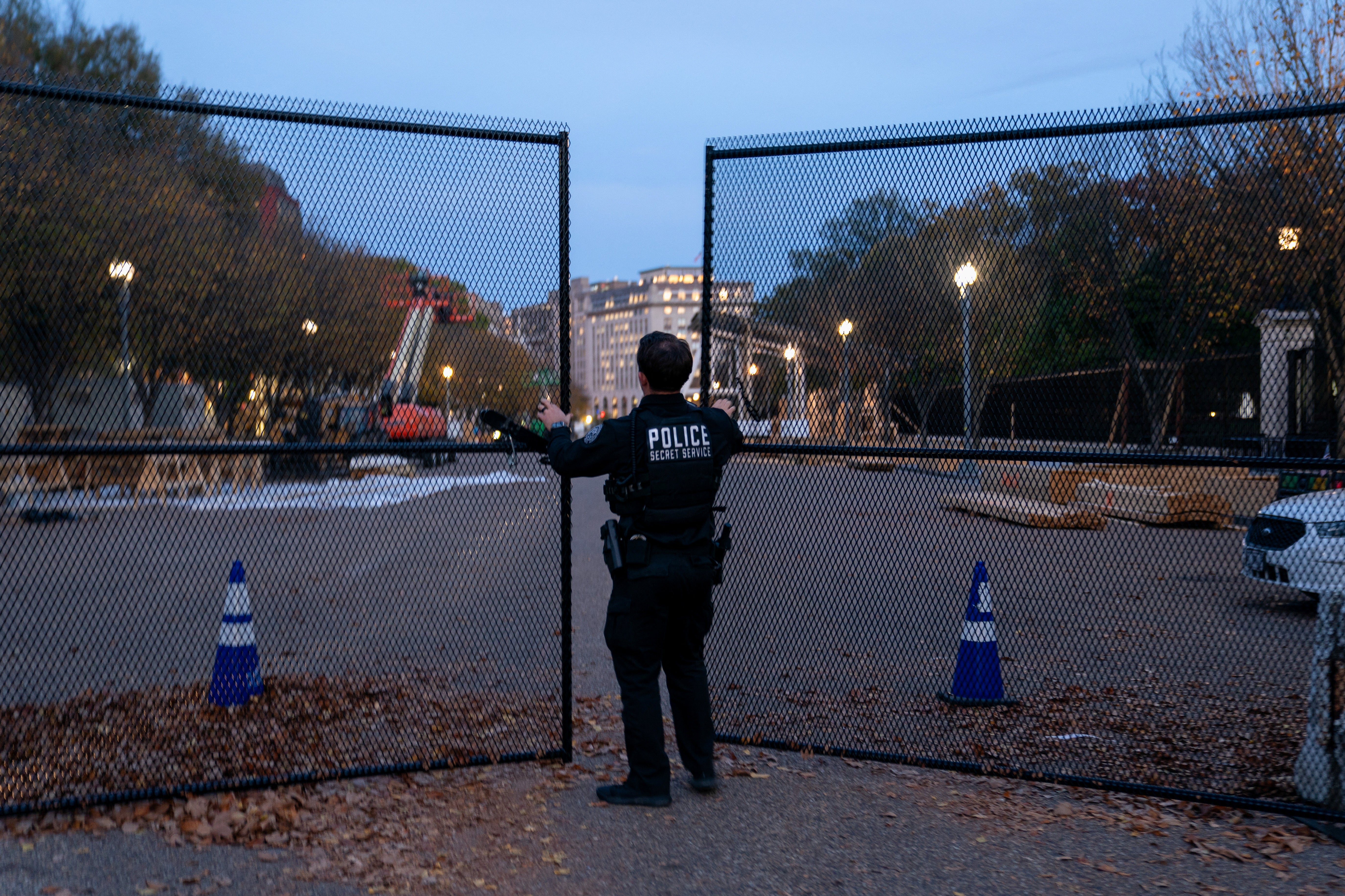 A member of the US Secret Service closes a security gate along Pennsylvania Avenue near the White House