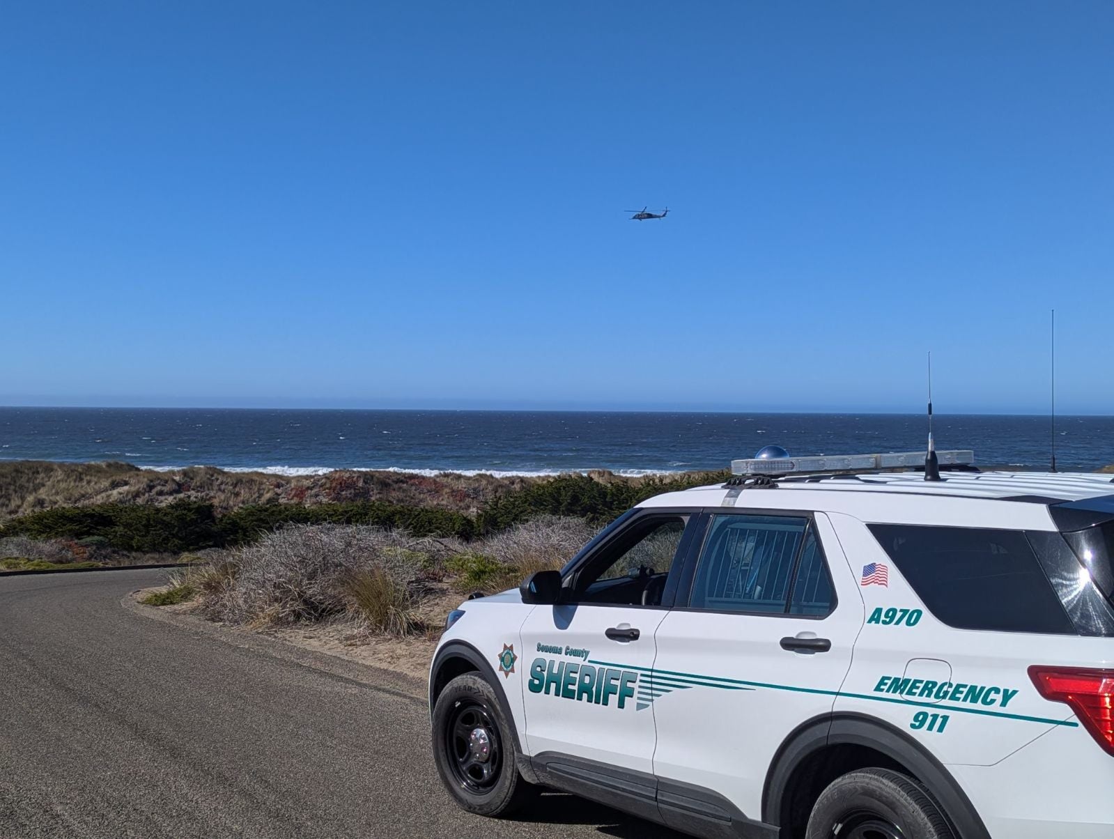 A Sonoma County Sheriff’s Office vehicle and a helicopter seen by California’s Bodega Bay during the search