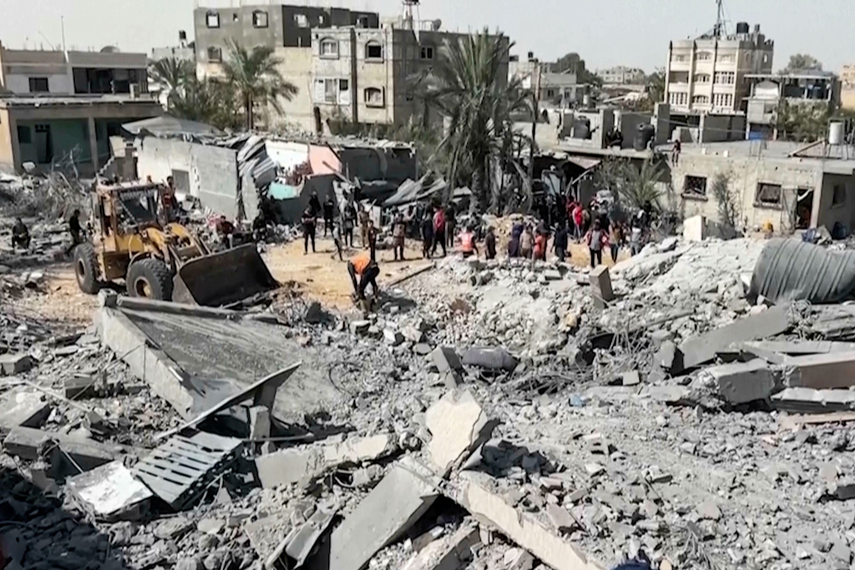 Palestinians gather near a building destroyed by Israeli airstrikes in the city of Khan Younis (AP)