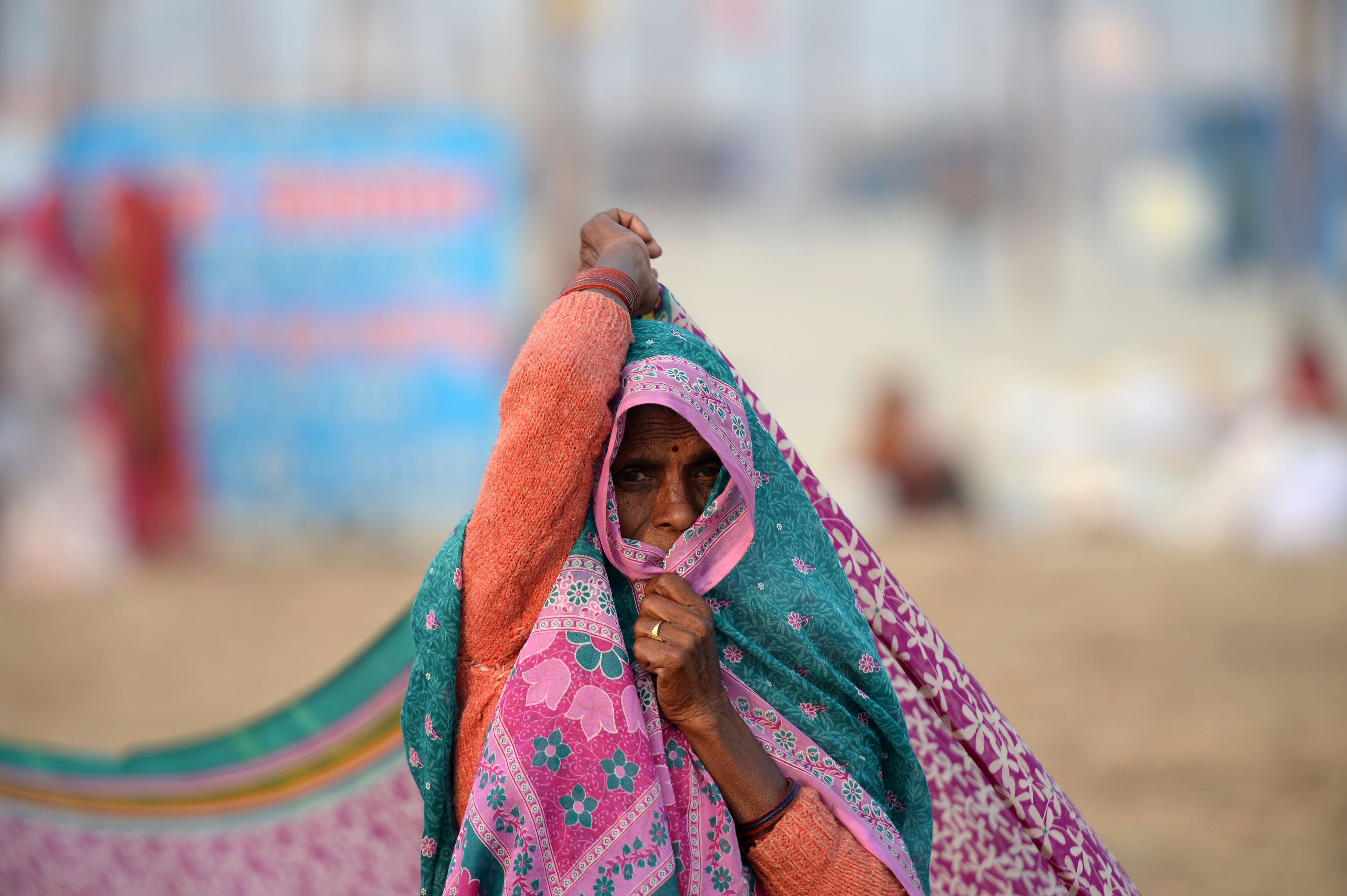 An Indian woman dries her sari after taking a dip at Sangam during the Magh Mela festival in Allahabad on January 9, 2018