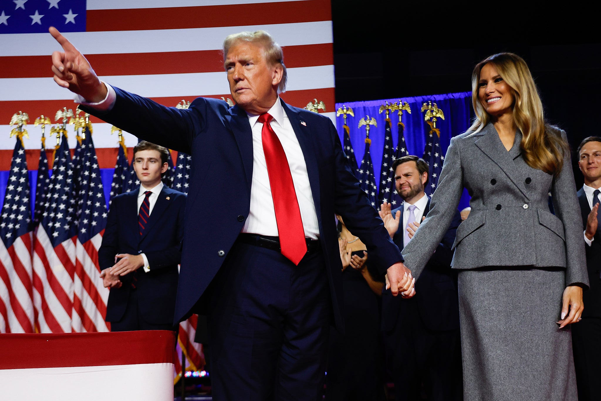 Republican presidential candidate former US President Donald Trump points to supporters with former first lady Melania Trump during an election night event at the Palm Beach Convention Center on November 6, 2024 in West Palm Beach, Florida