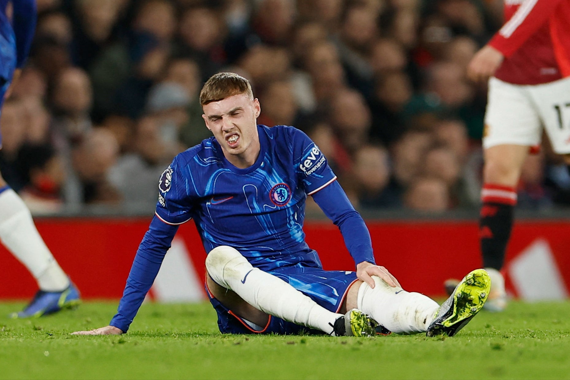 Cole Palmer grimaces after a challenge from Lisandro Martinez