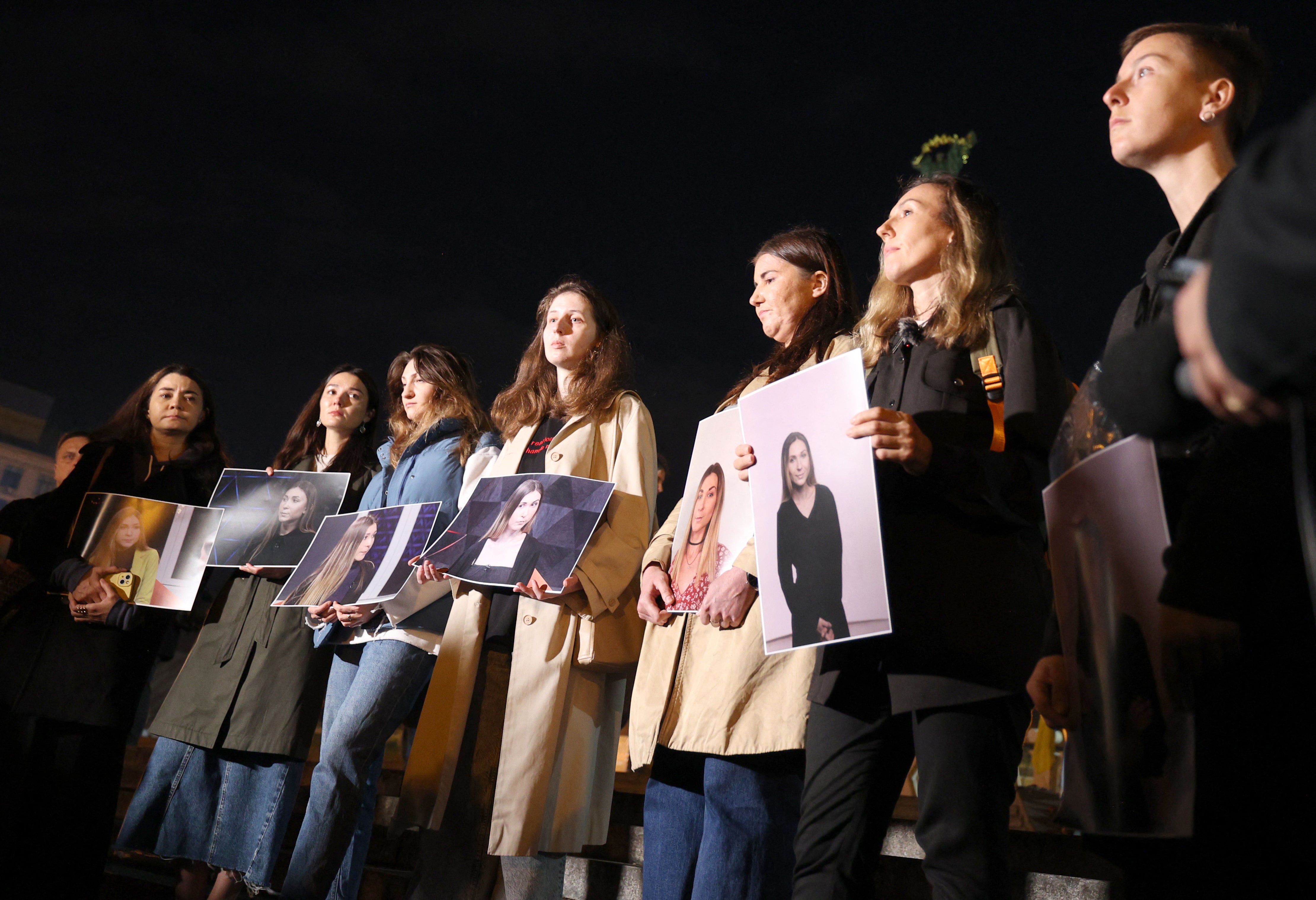 Colleagues of Ukrainian journalist Victoria Roshchyna hold photographs of her during an event in honour of her memory at a makeshift memorial for fallen Ukrainian soldiers at Independence Square in Kyiv