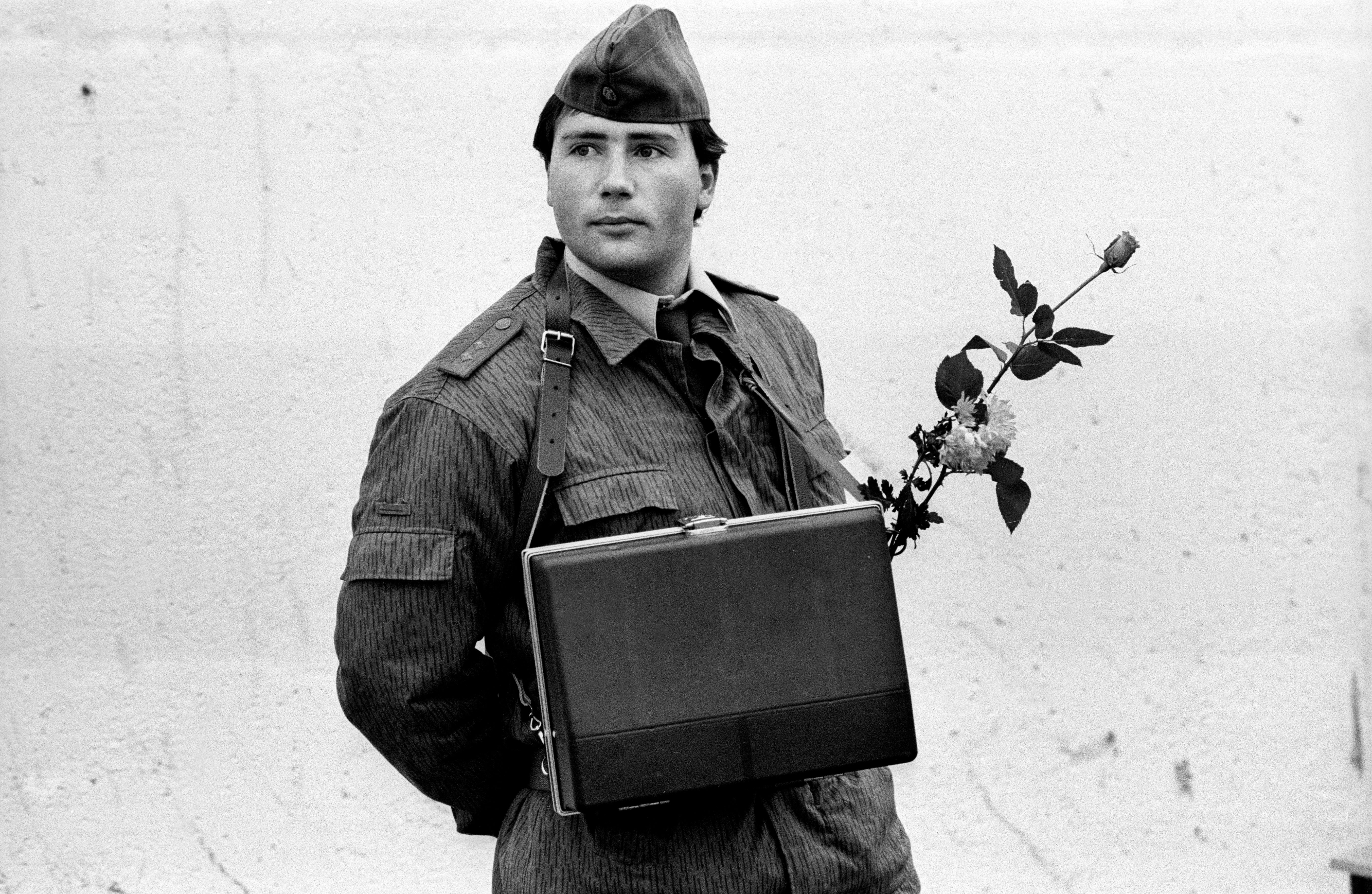 The morning after: an East German border guard stands by with a flower in his case, 10 November 1989