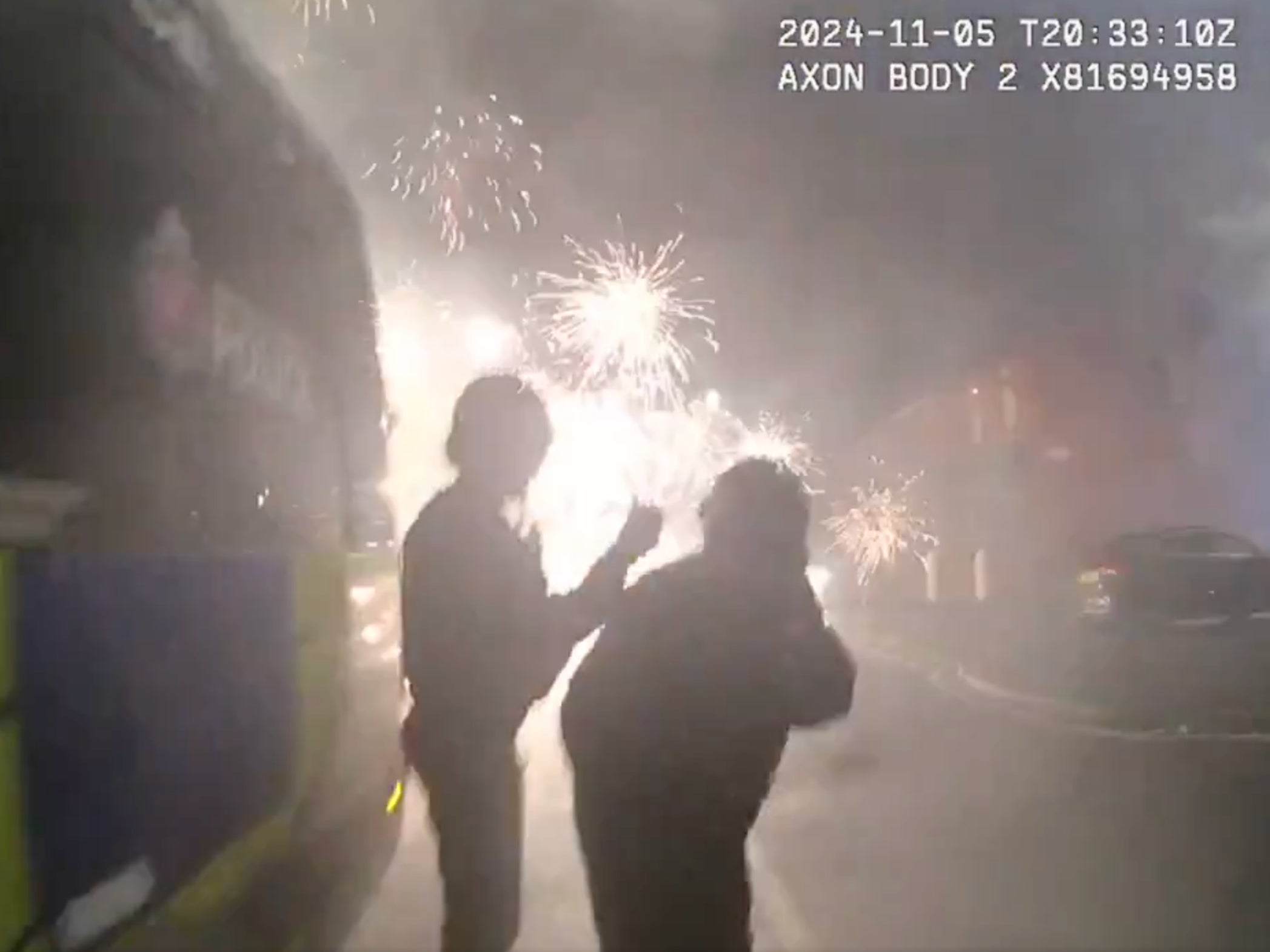 One officer tries to get shields out of the back of a riot van but finds himself briefly pinned by yobs hurling fireworks