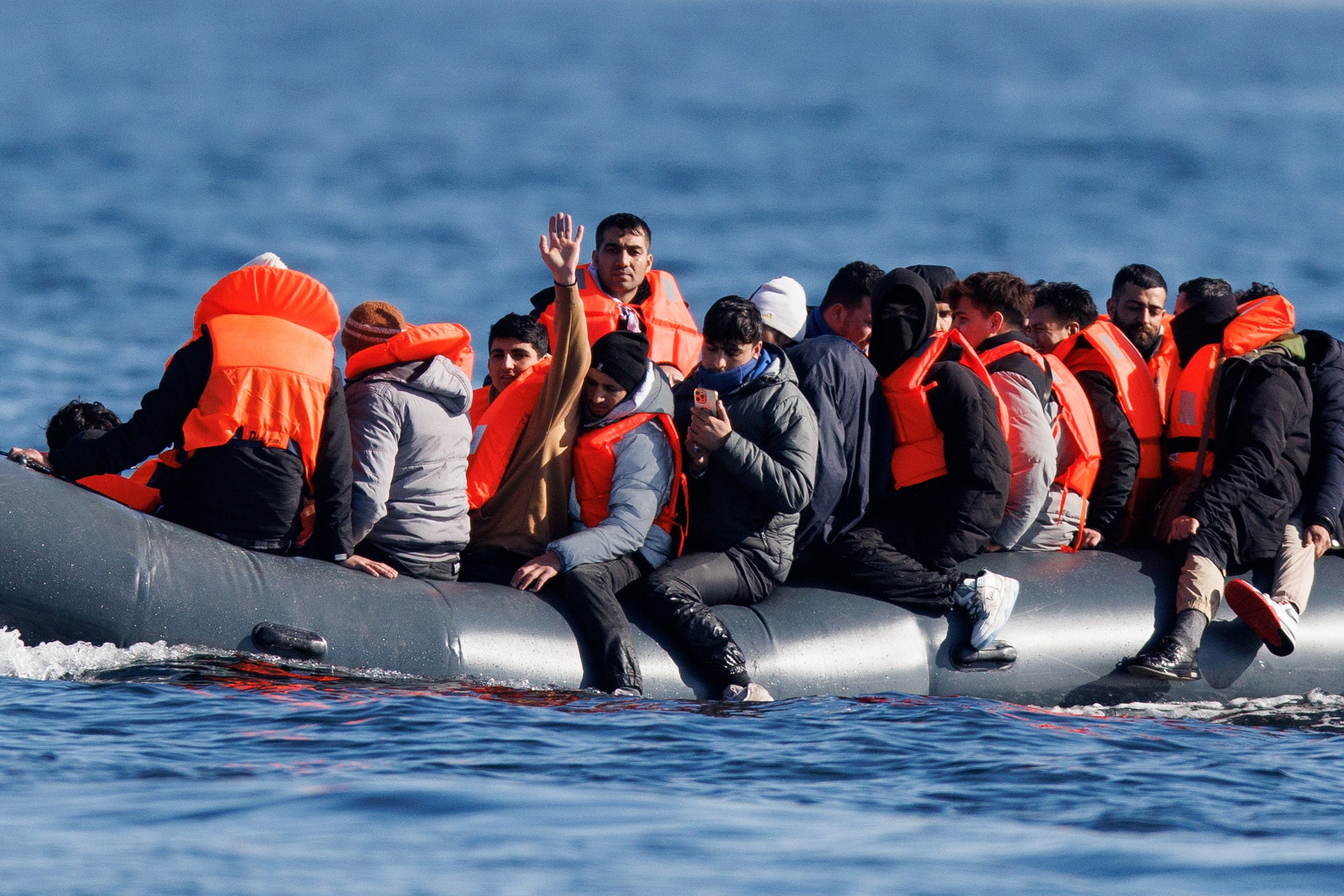 Migrants pictured crossing the English Channel on a small boat earlier this year