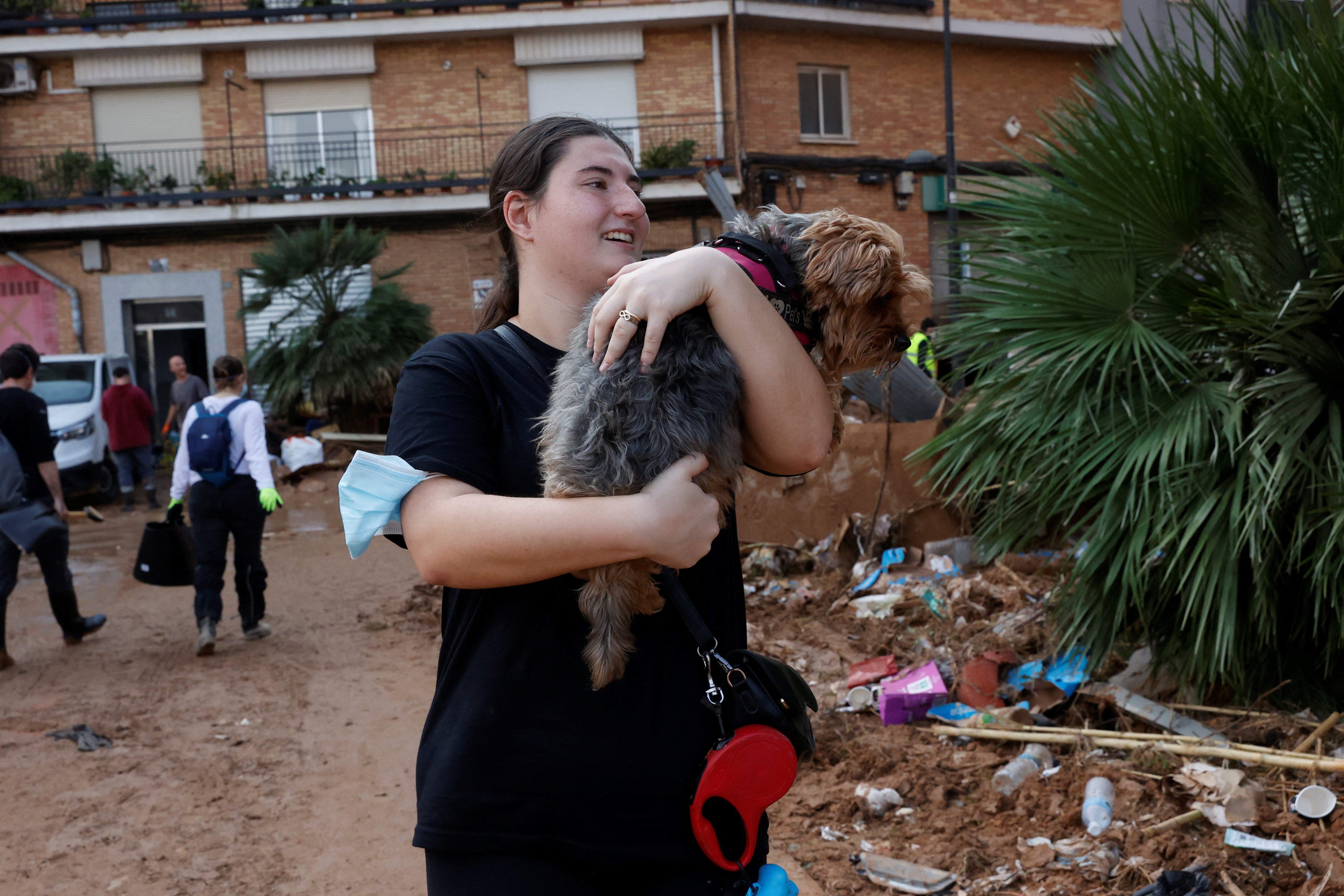 Laura, 20, holds a dog as she searches for a veterinarian on the muddy streets in Paiporta, Valencia