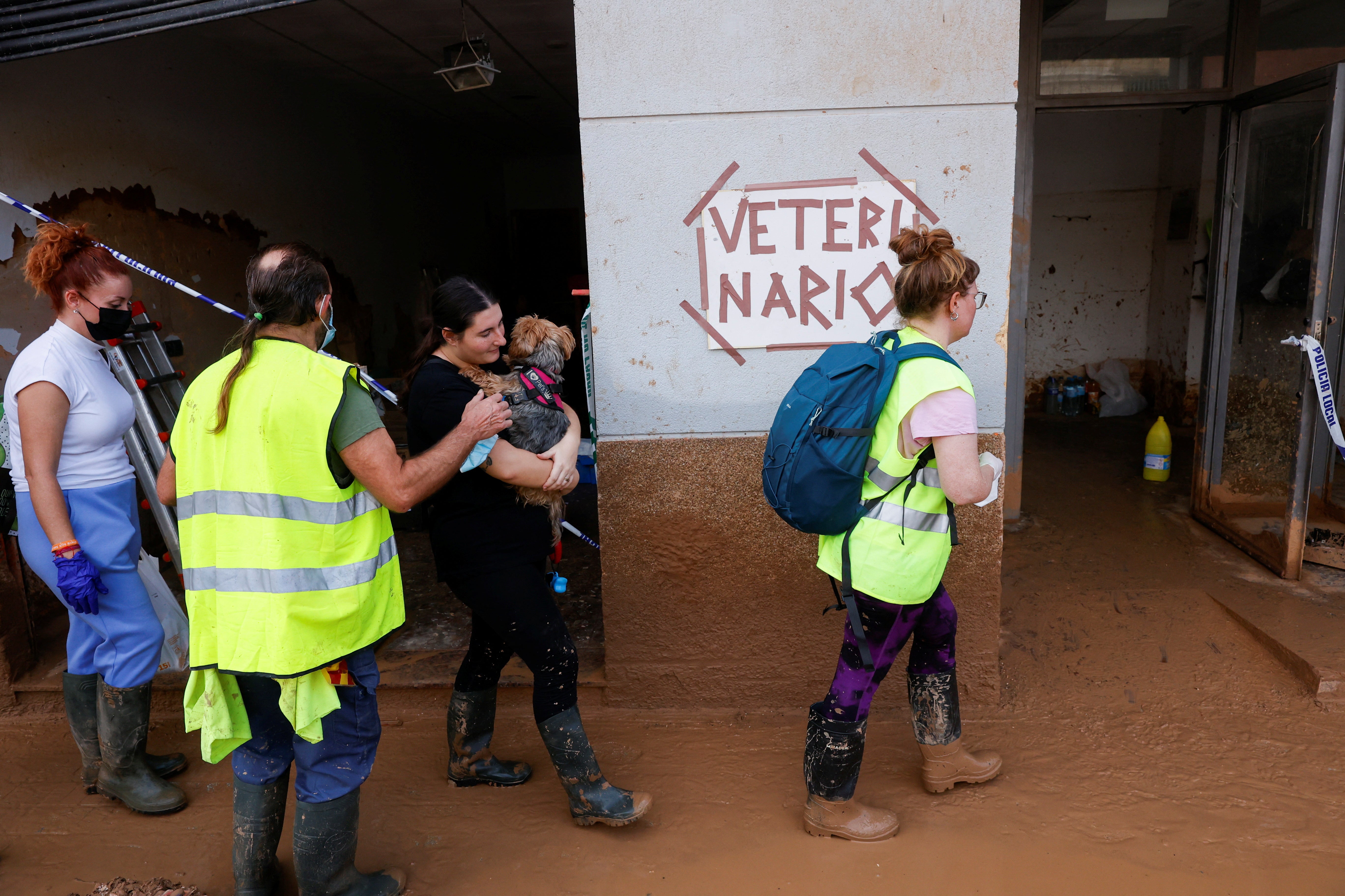 Laura, 20, holds her dog as she searches for a veterinarian on the muddy streets in Paiporta, Valencia