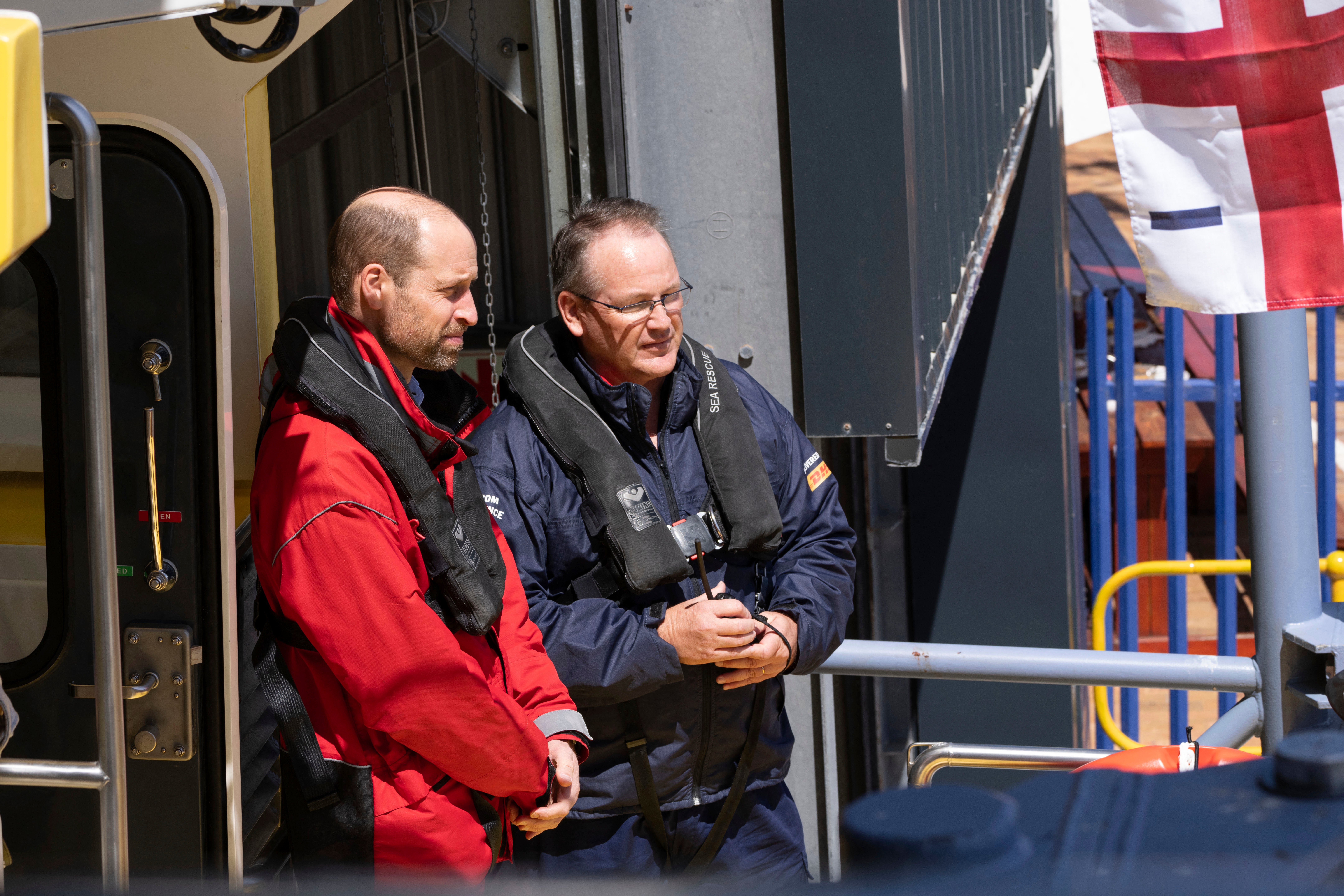 Prince William (L), Prince of Wales, sails off with volunteers from the National Sea Rescue Initiative (NSRI) near Simon's Town harbour,