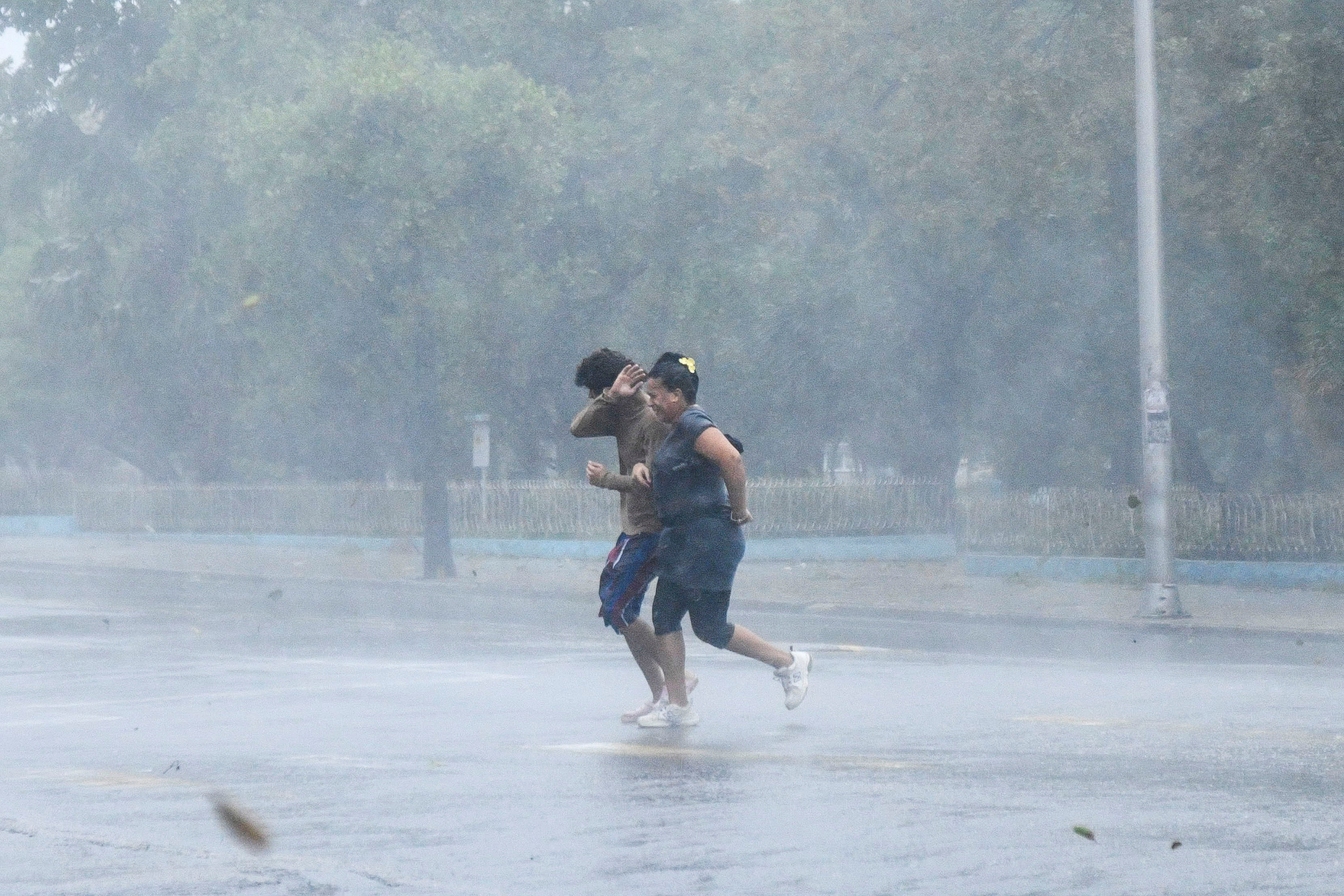 People run on the street as Hurricane Rafael passes by Havana, Cuba, on Wednesday. The storm is forecast to bring more heavy rain to the island on Thursday.