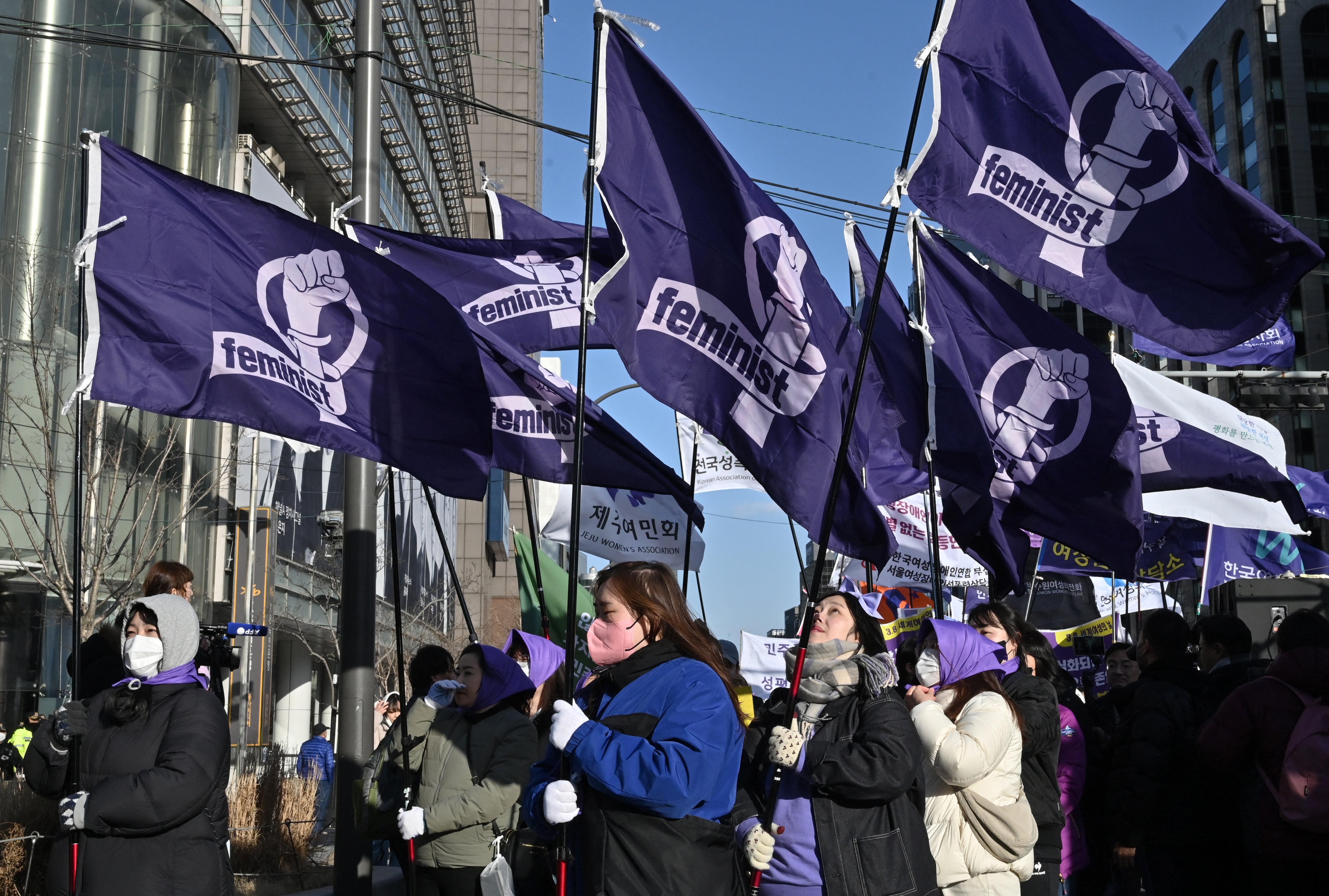 Women in South Korea carry flags that say ‘Feminist’ to mark International Women’s Day