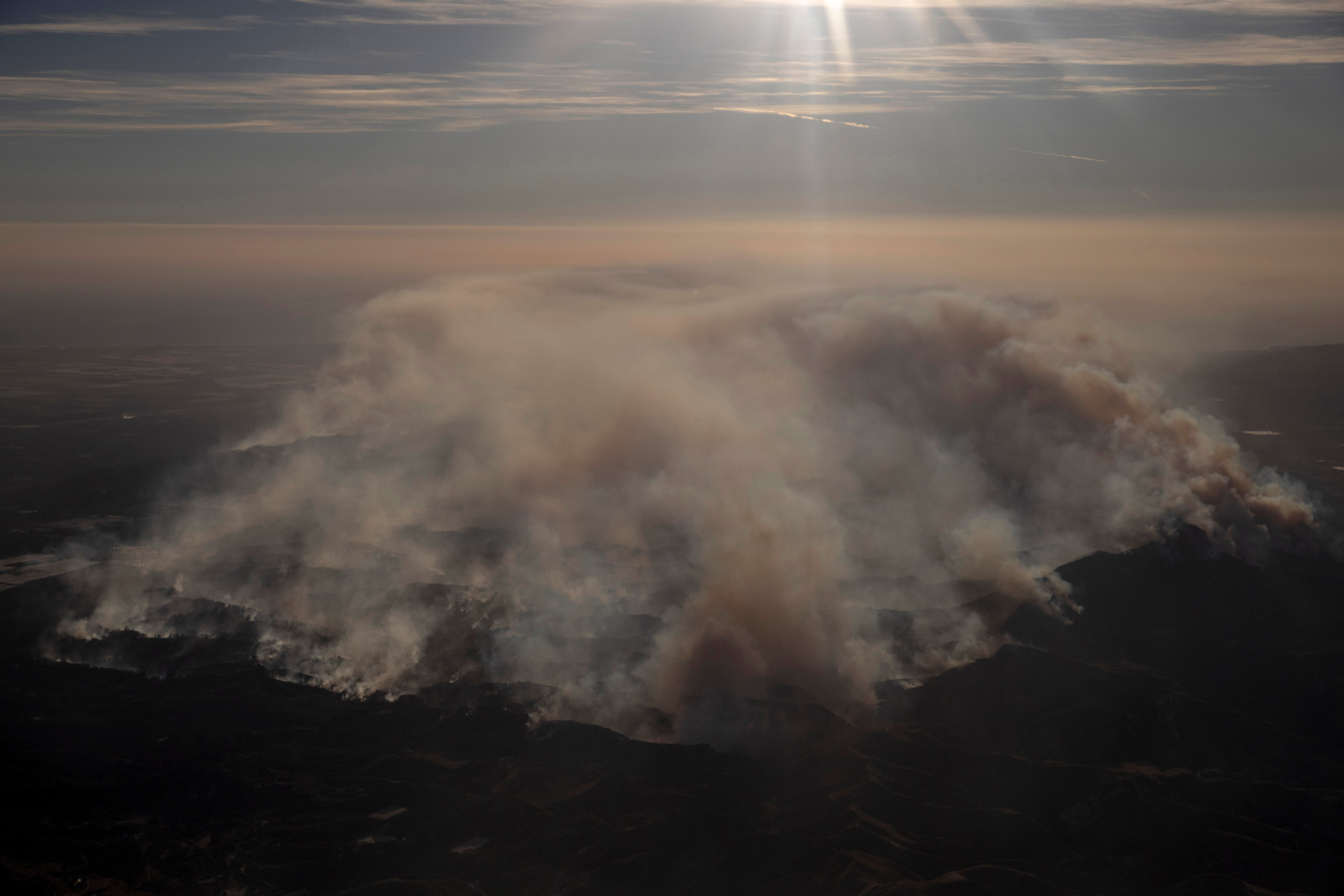 Smoke rises from the Mountain Fire as seen from a commercial flight near Ventura County, California. Thick smoke from the blaze blanketed otherwise clear skies.