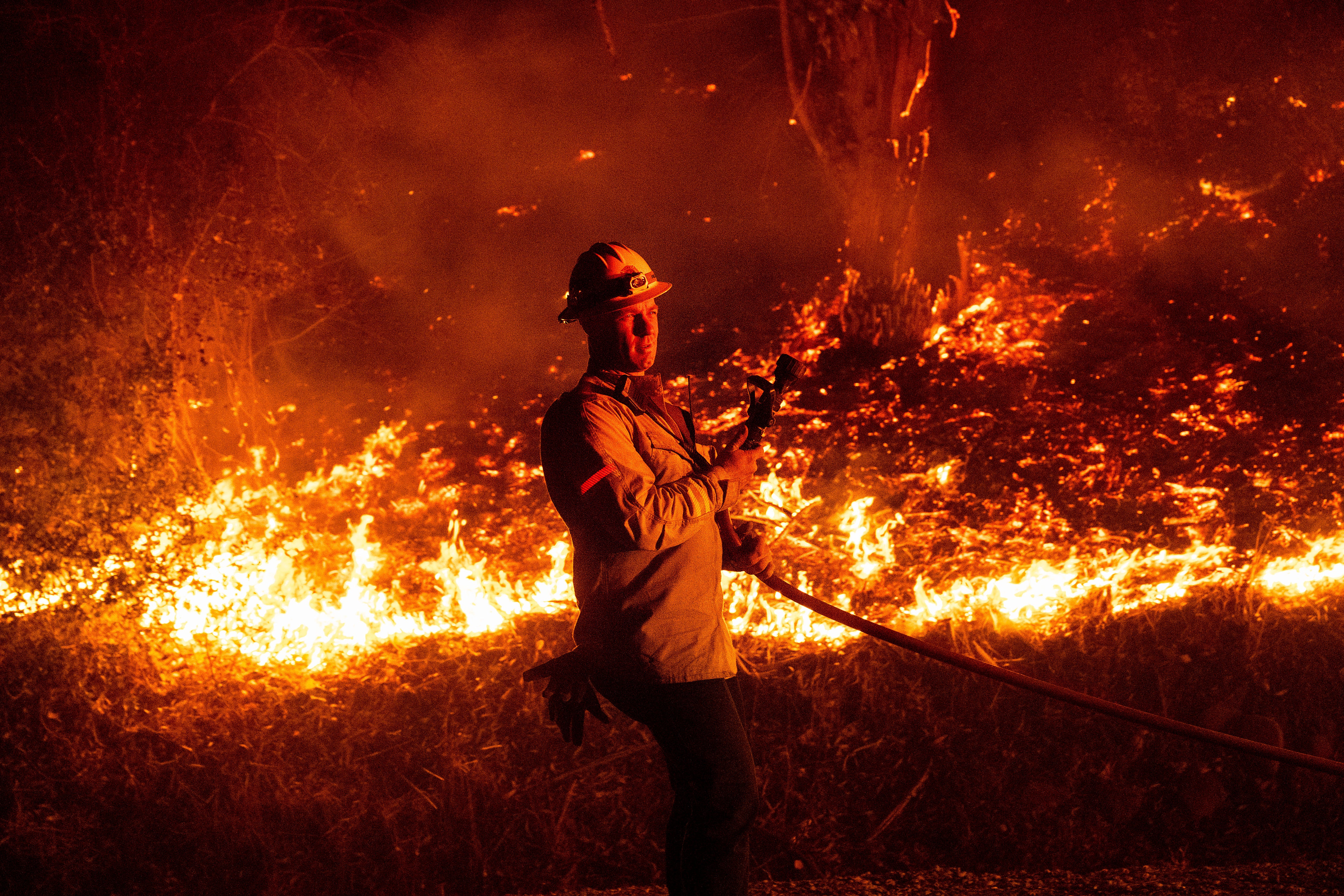 A firefighter prepares to attack flames from the Mountain Fire in Santa Paula, California, on Wednesday. Hundreds of firefighters and officials have responded to the hazard.