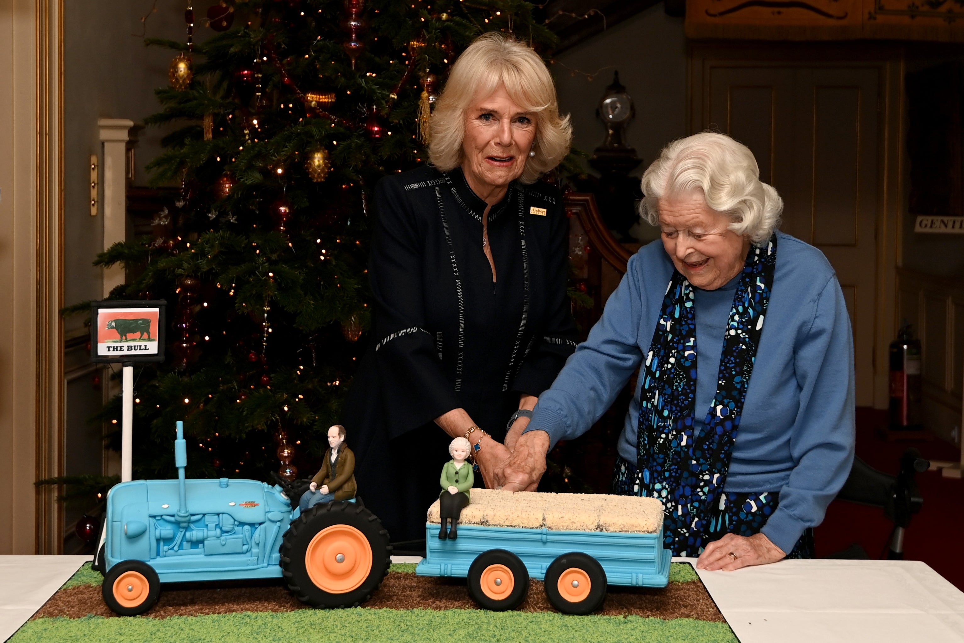 Queen Camilla and June Spencer cut an Archers-themed cake during a celebration of the programme’s 70th anniversary