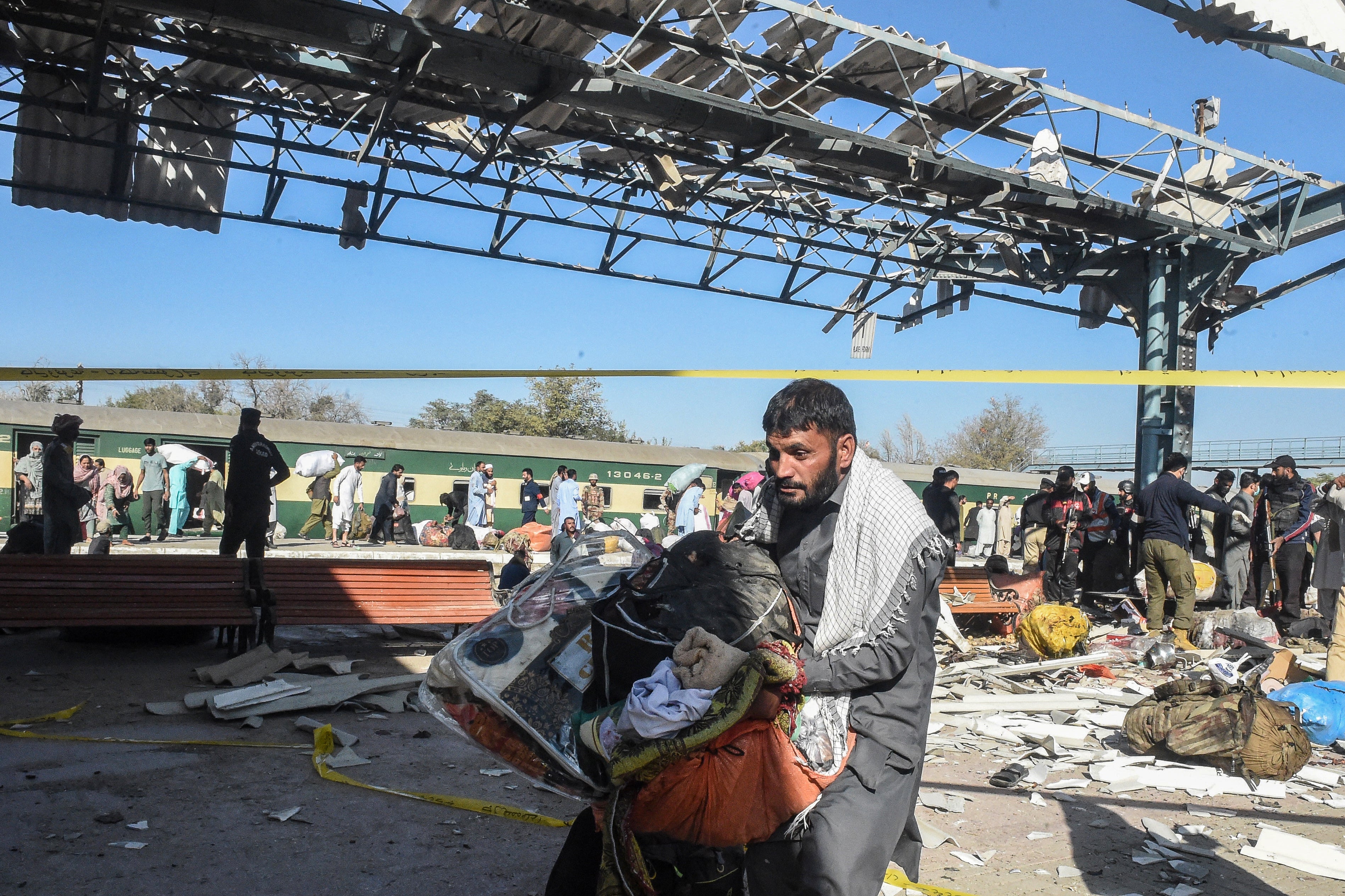 A man carries passengers’ belongings from the blast site after the explosion