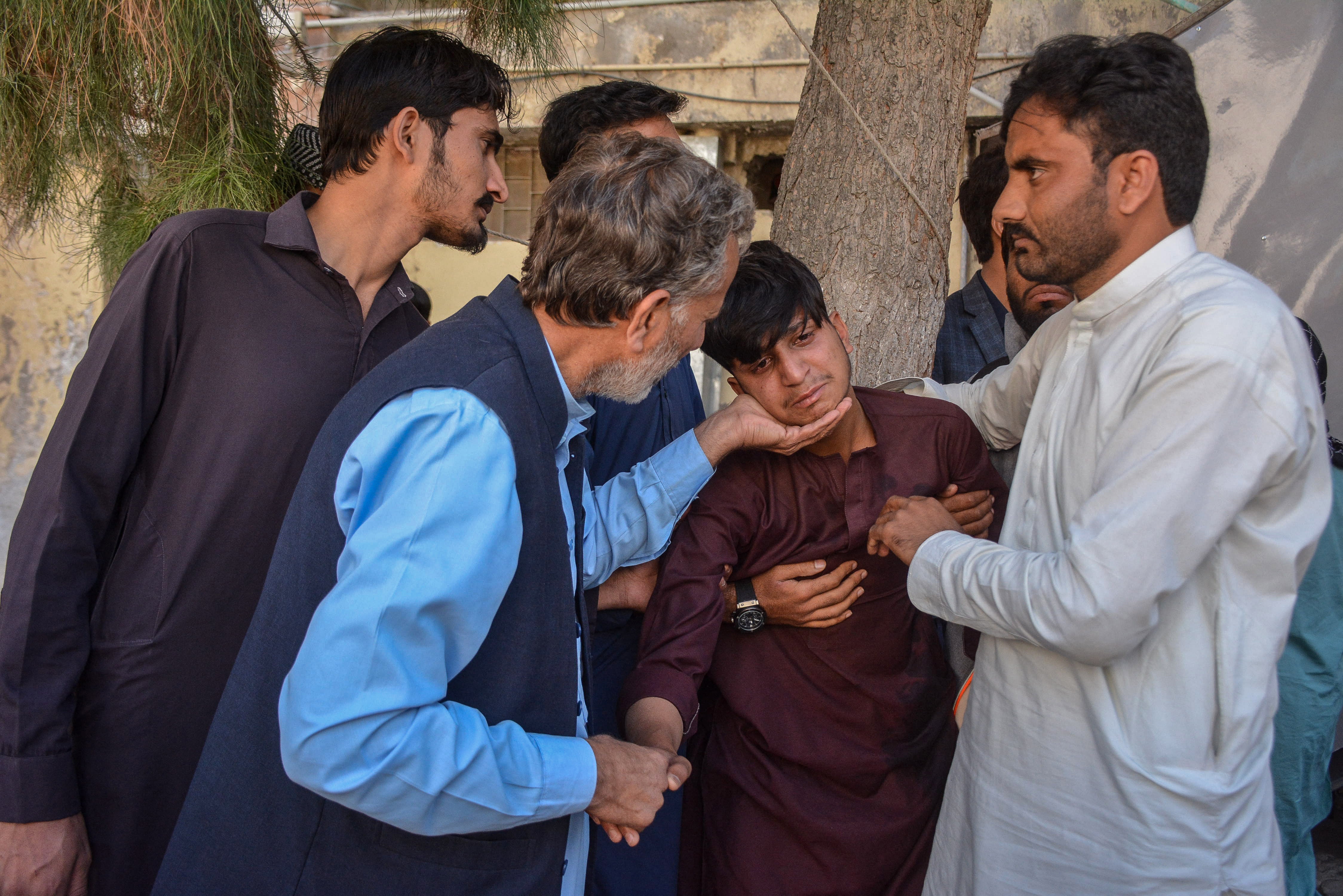 People mourn the death of their relatives in a hospital following a bomb blast at a railway station in Quetta