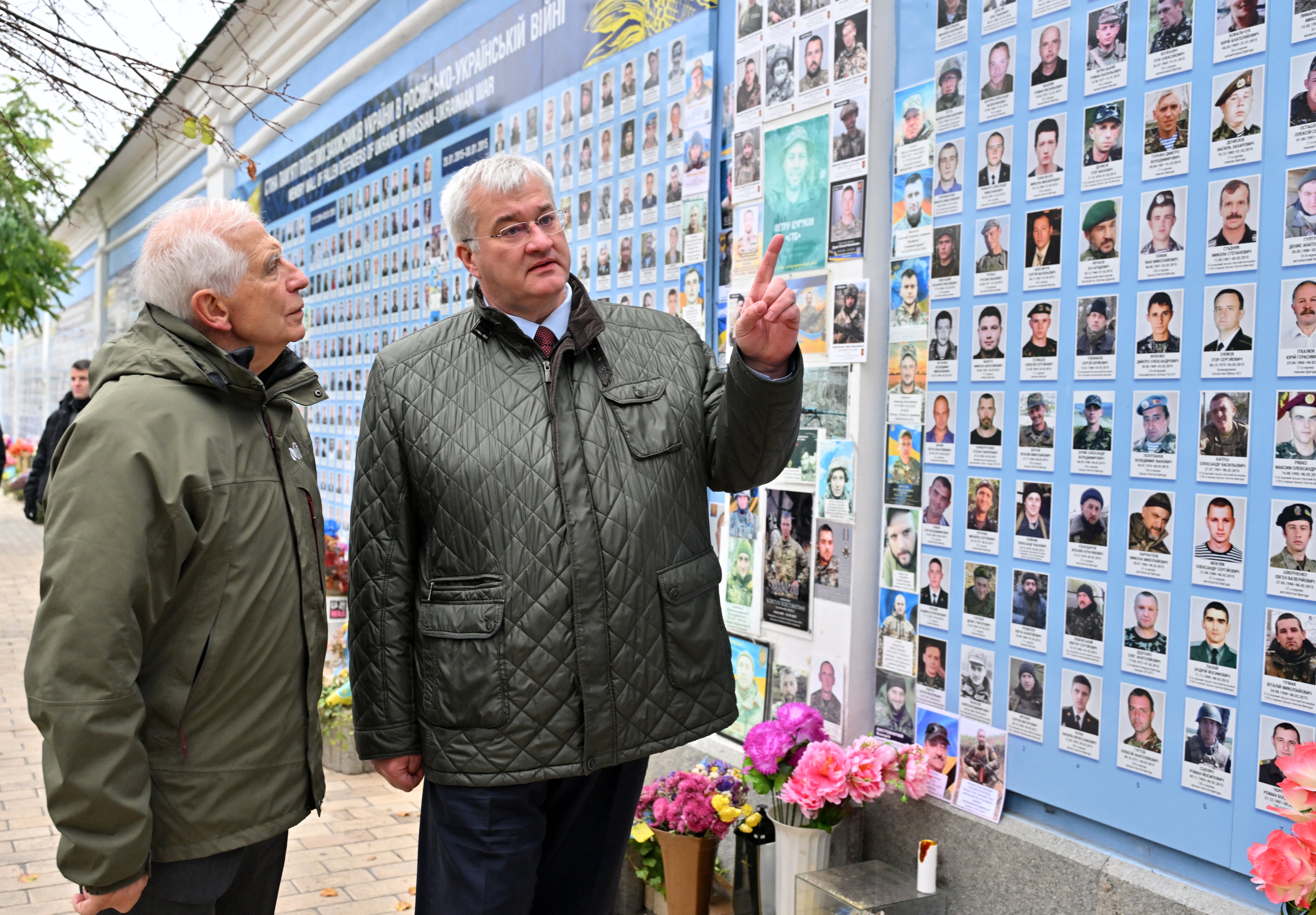 High Representative of the European Union for Foreign Affairs and Security Policy Josep Borrell (L) and Ukraine's Foreign Minister Andrii Sybiha speak before the Memory Wall of Fallen Defenders of Ukraine after a flower laying ceremony outside Saint Michael's Cathedral in Kyiv