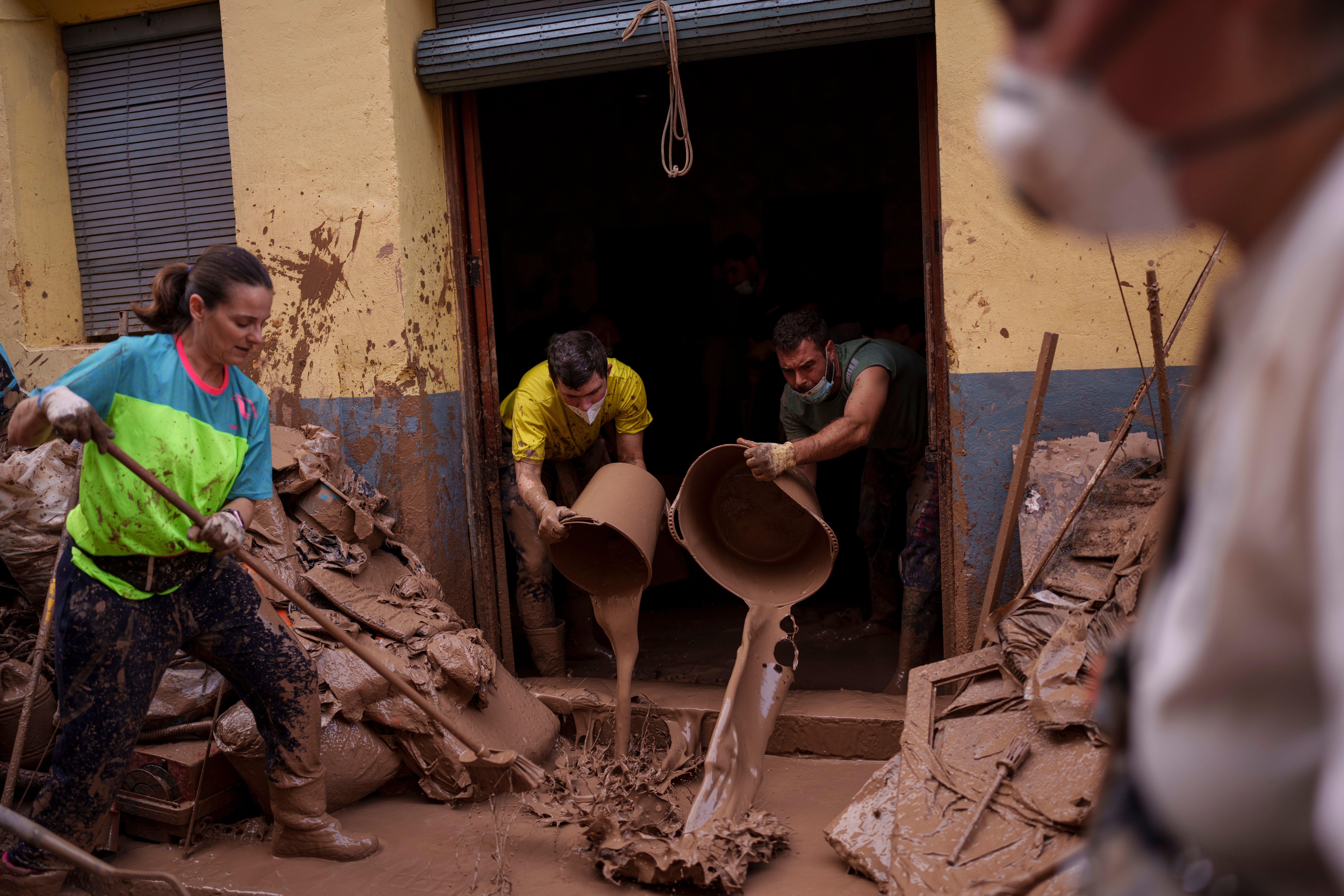 People clear mud from a flooded house in Algemesi in October; there are fears a new weather front could bring more devastation