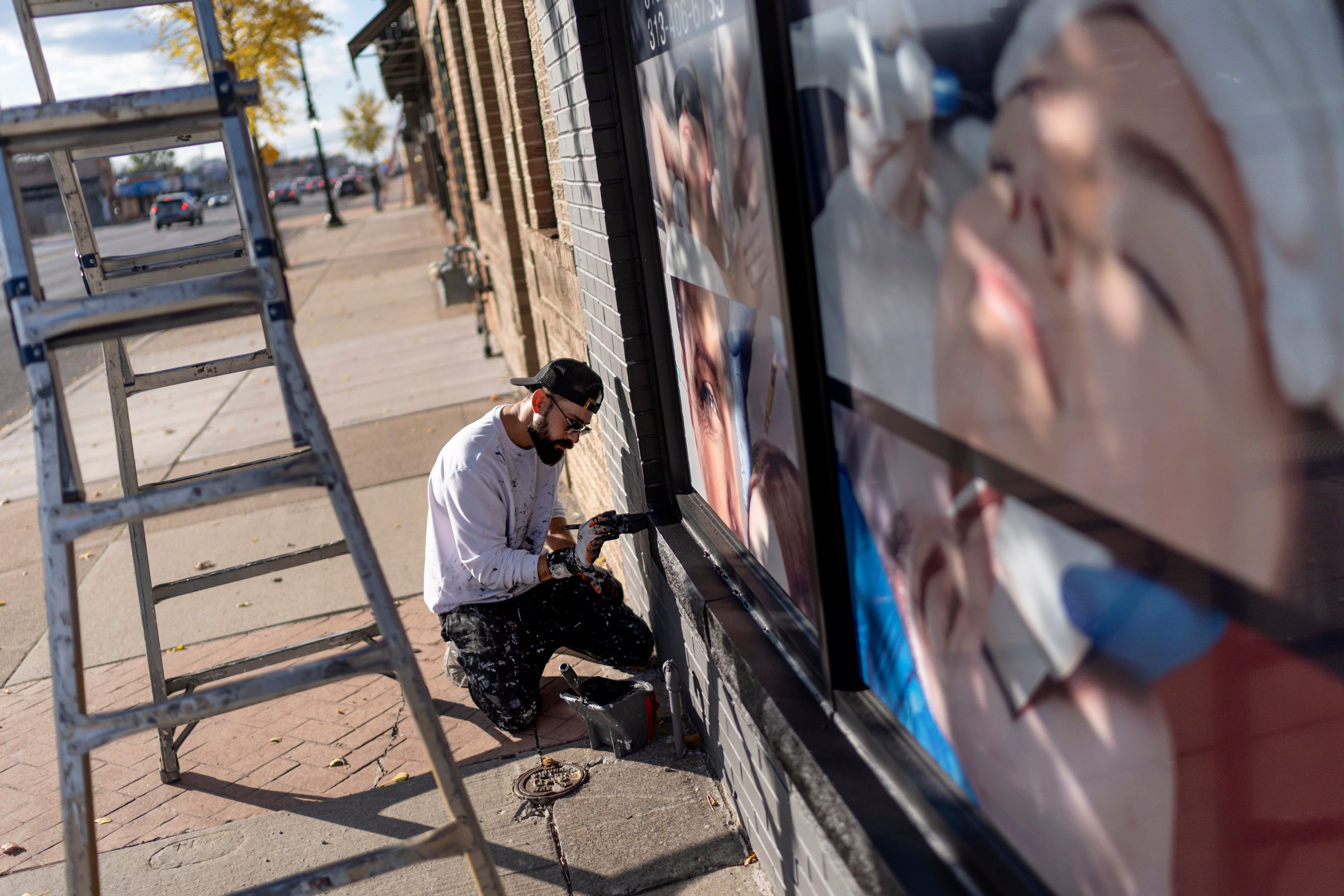 Adam Hameed, paints the exterior of a skin care center, Wednesday, Nov. 6, 2024, in Dearborn, Mich., the nation's largest Arab-majority city.