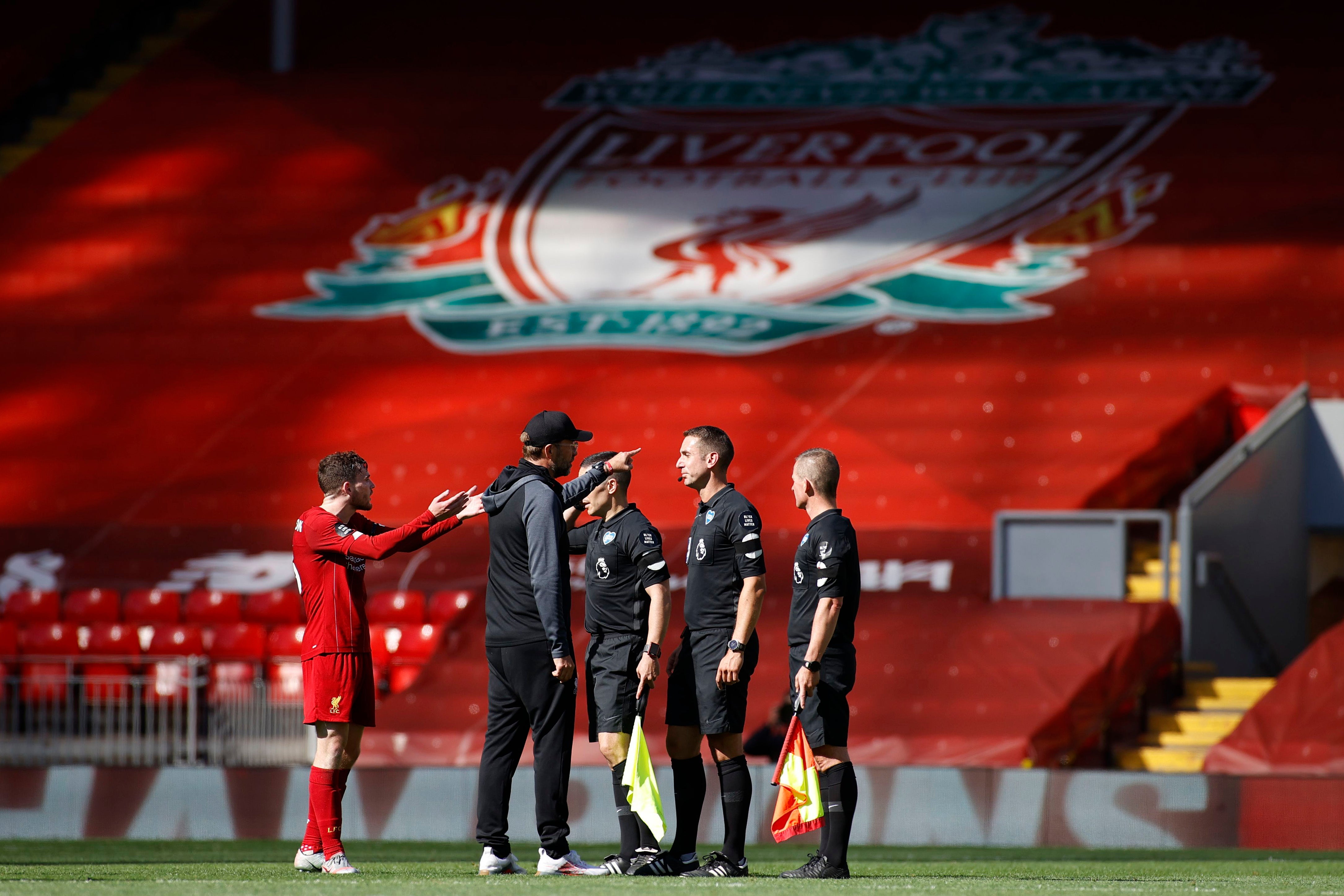 Liverpool’s Jurgen Klopp and Andrew Robertson confront referee David Coote