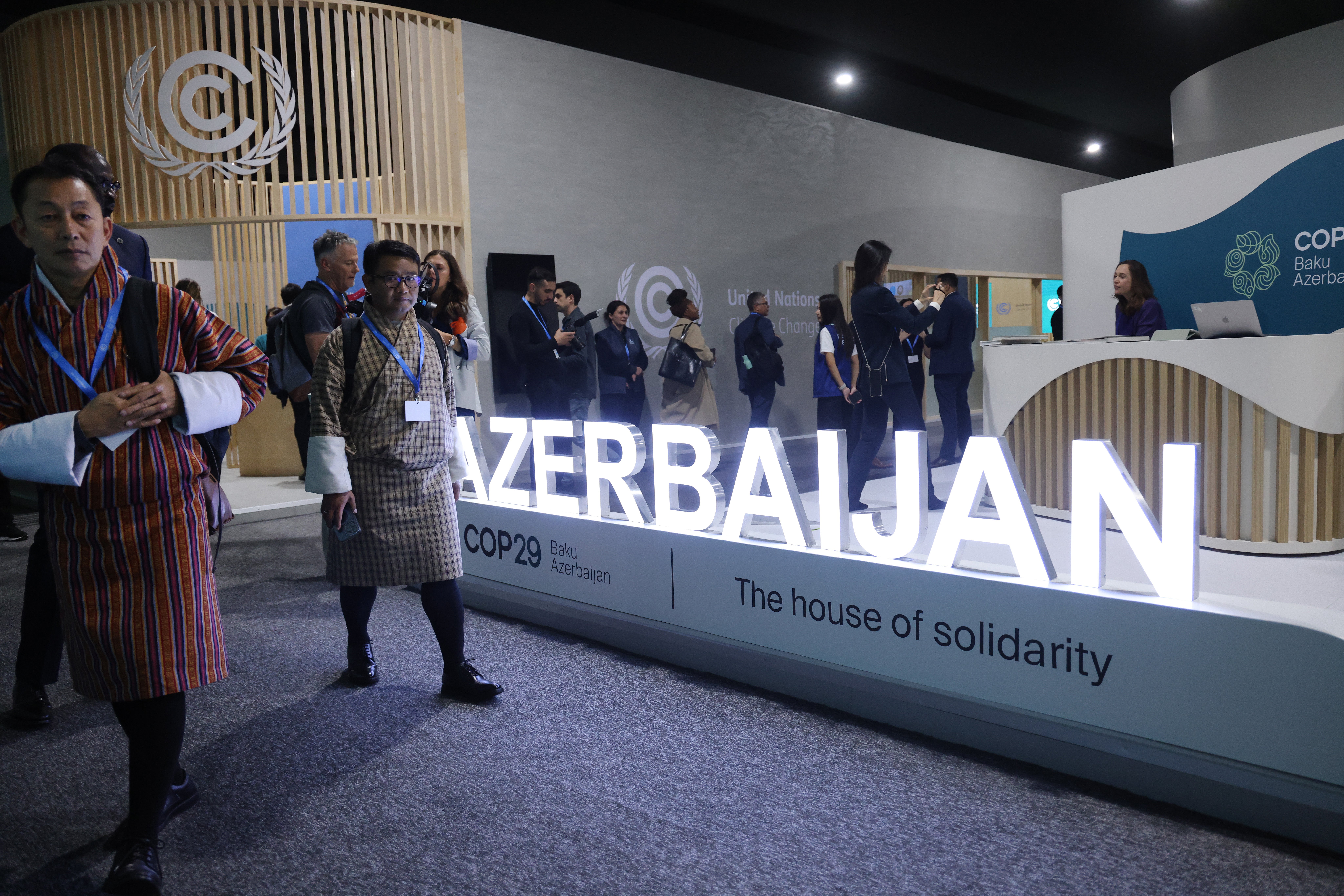 Participants walk past the Azerbaijan pavilion on the opening day of the COP29 Climate Conference