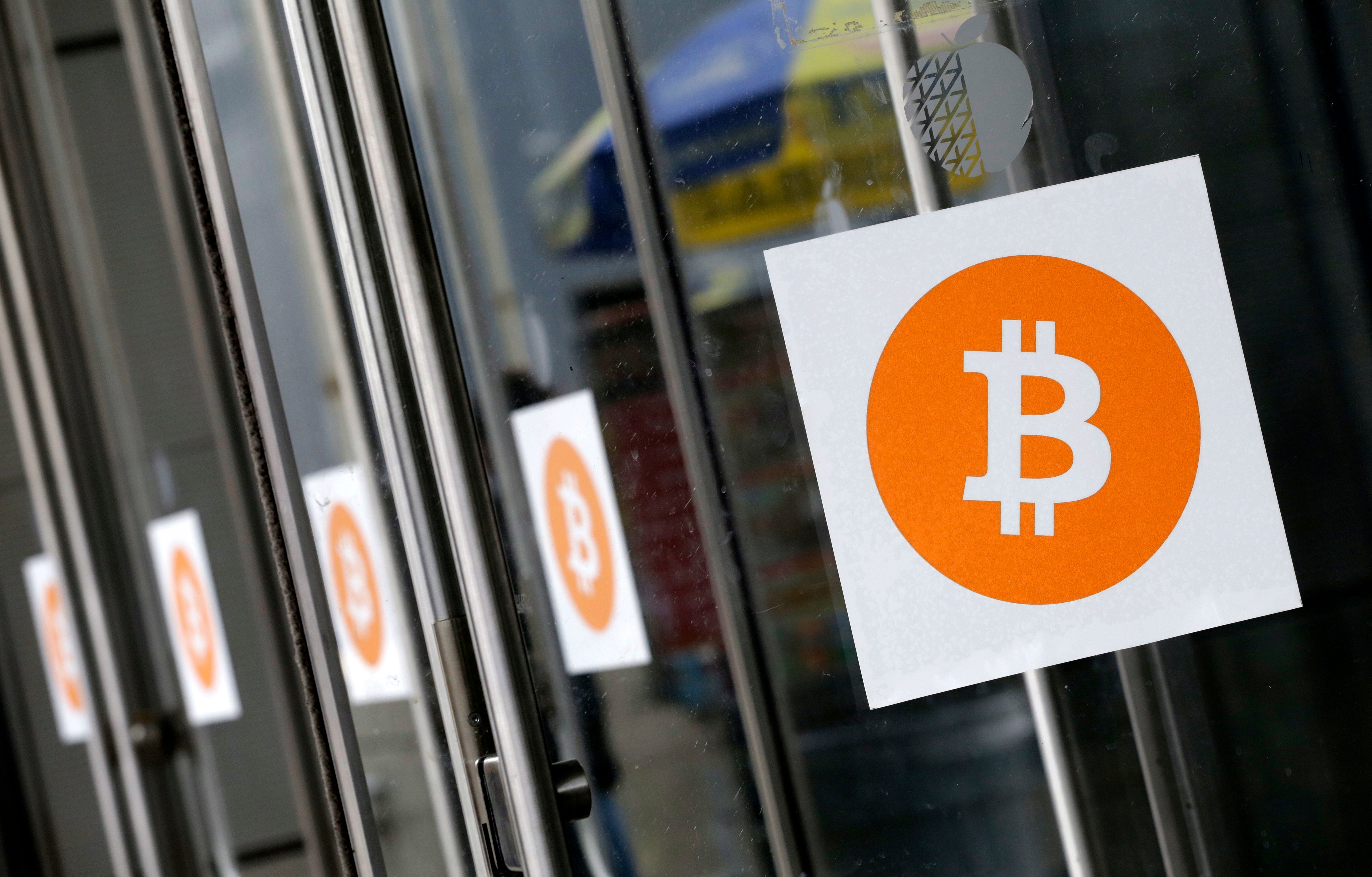Bitcoin logos are displayed at the Inside Bitcoins conference and trade show on 7 April, 2014, in New York