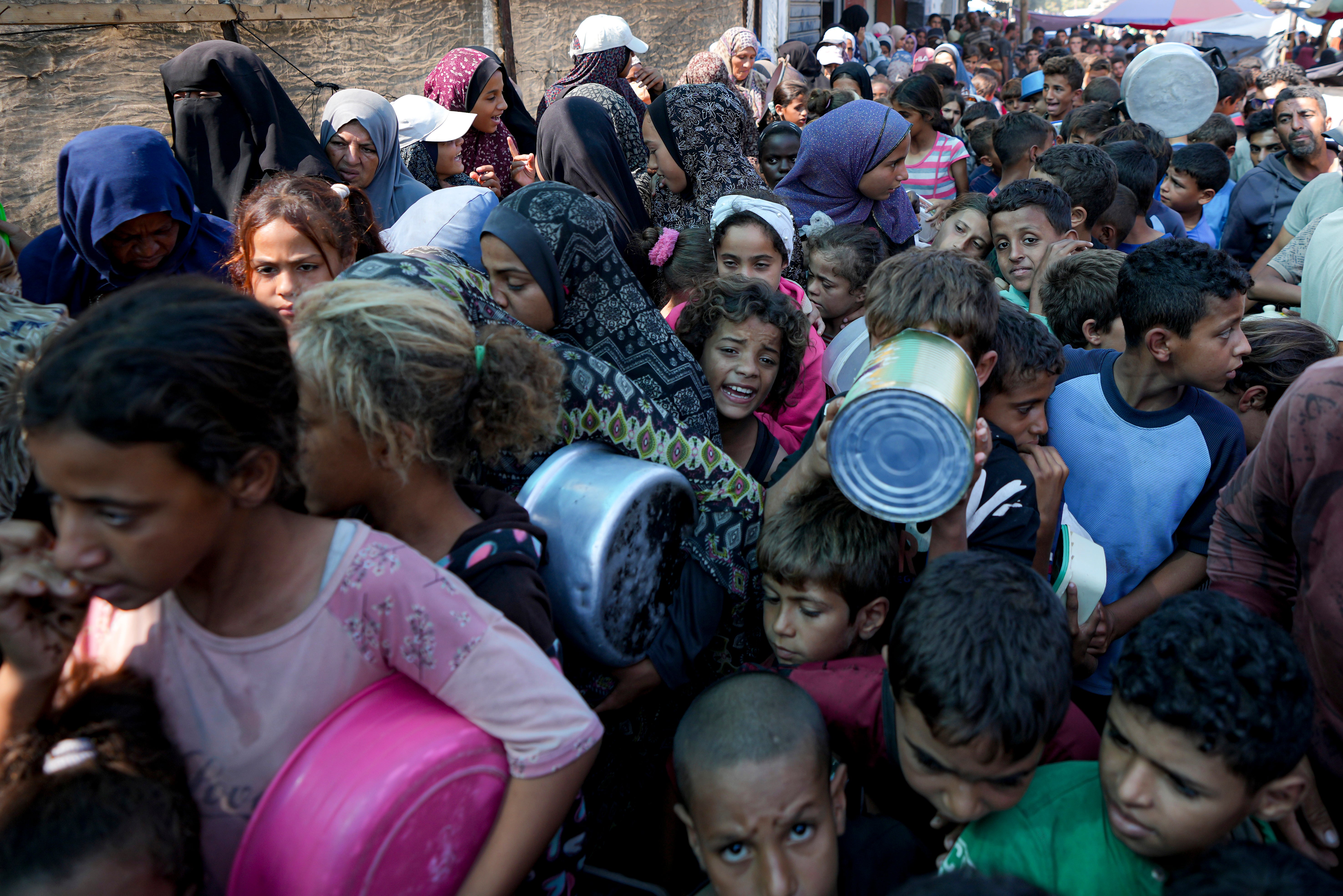 Palestinians line up for food distribution in Deir al-Balah, Gaza Strip