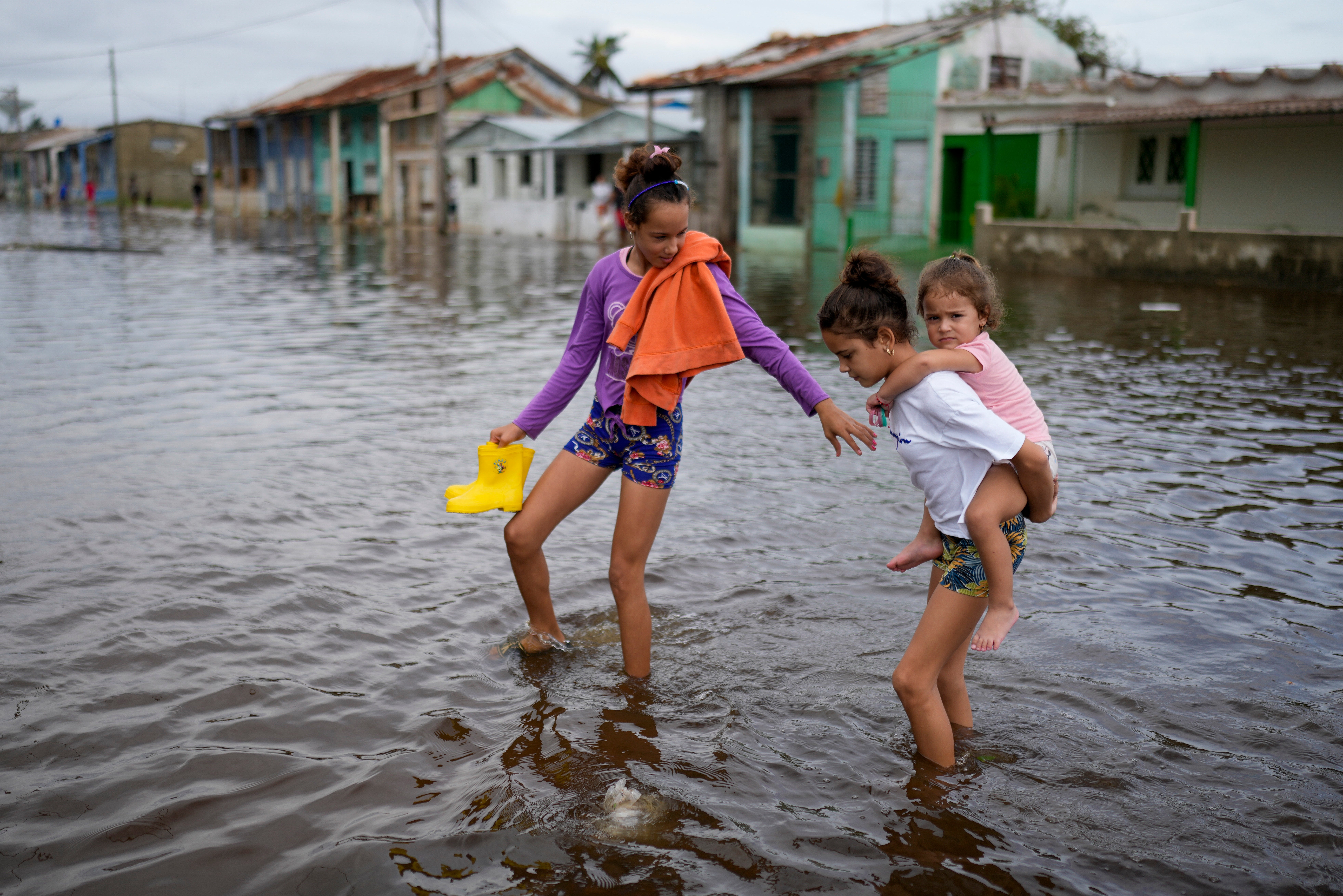 Children wade through a flooded street after Hurricane Rafael in Batabano, Cuba, earlier this month. The storm was followed by a major earthquake