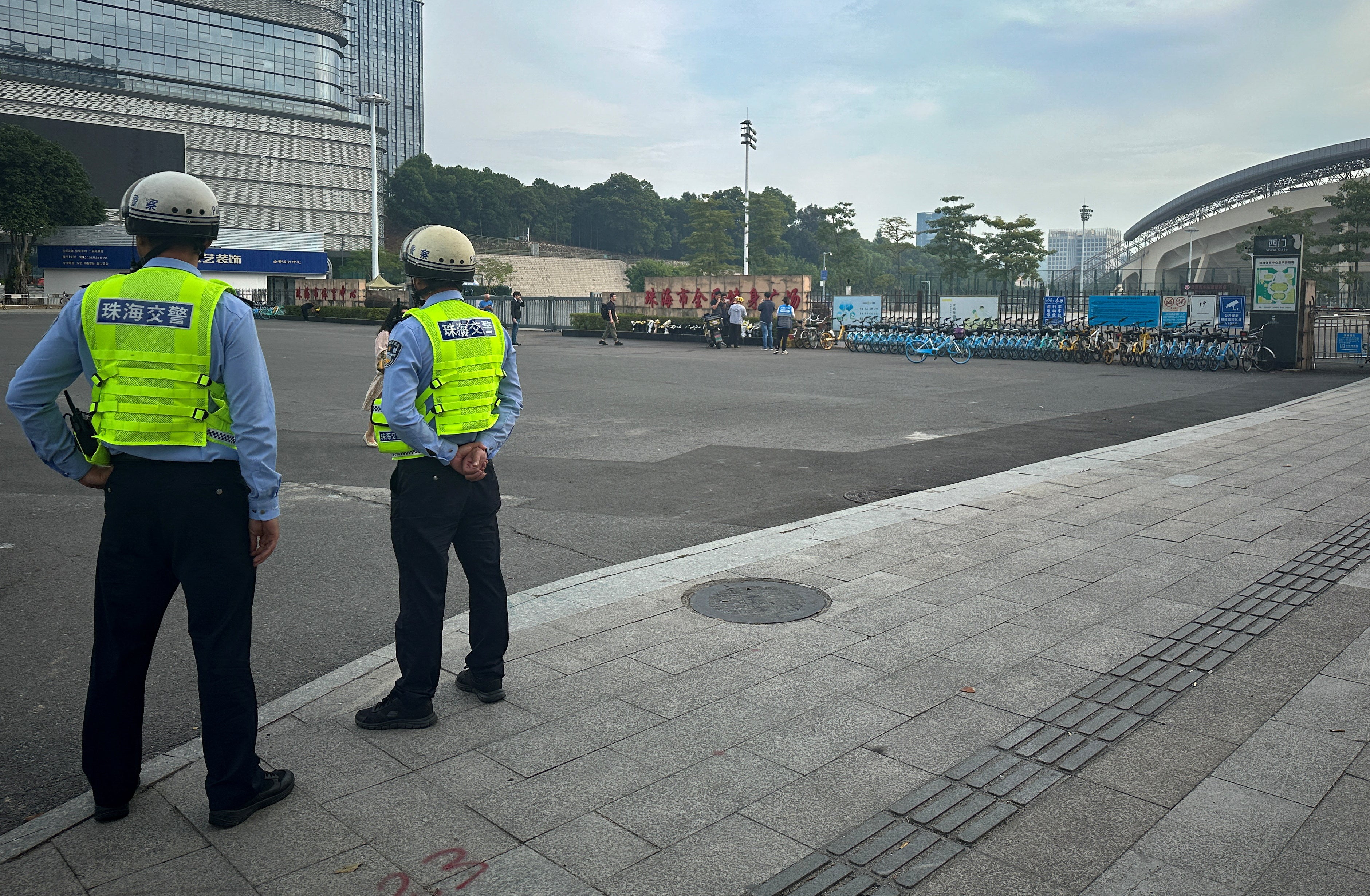 Police officers stand outside a sports centre where a deadly car attack took place, in Zhuhai