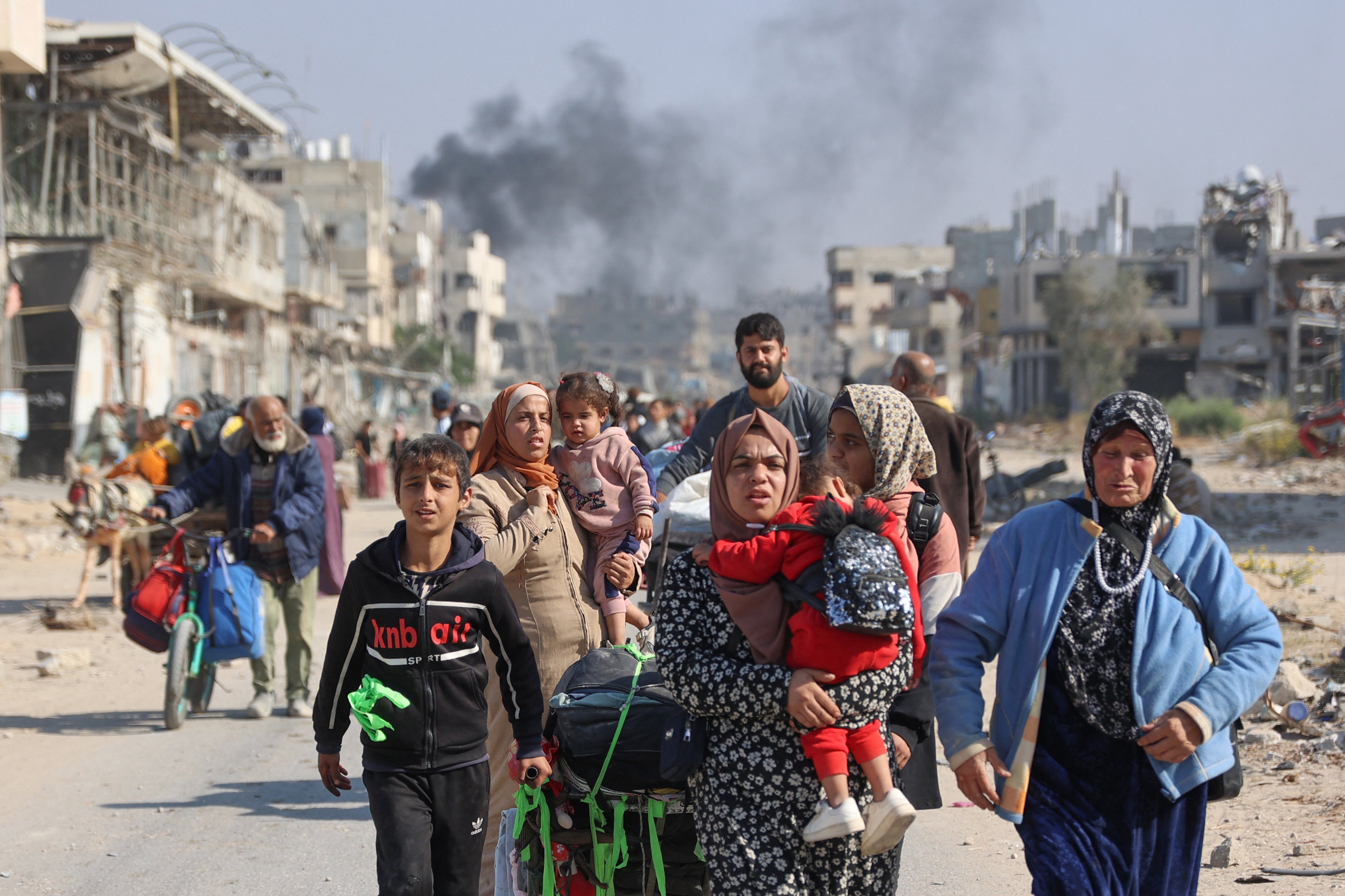 Palestinians displaced from shelters in Beit Hanoun cross the main Salaheddin road into Jabalia in the northern Gaza Strip