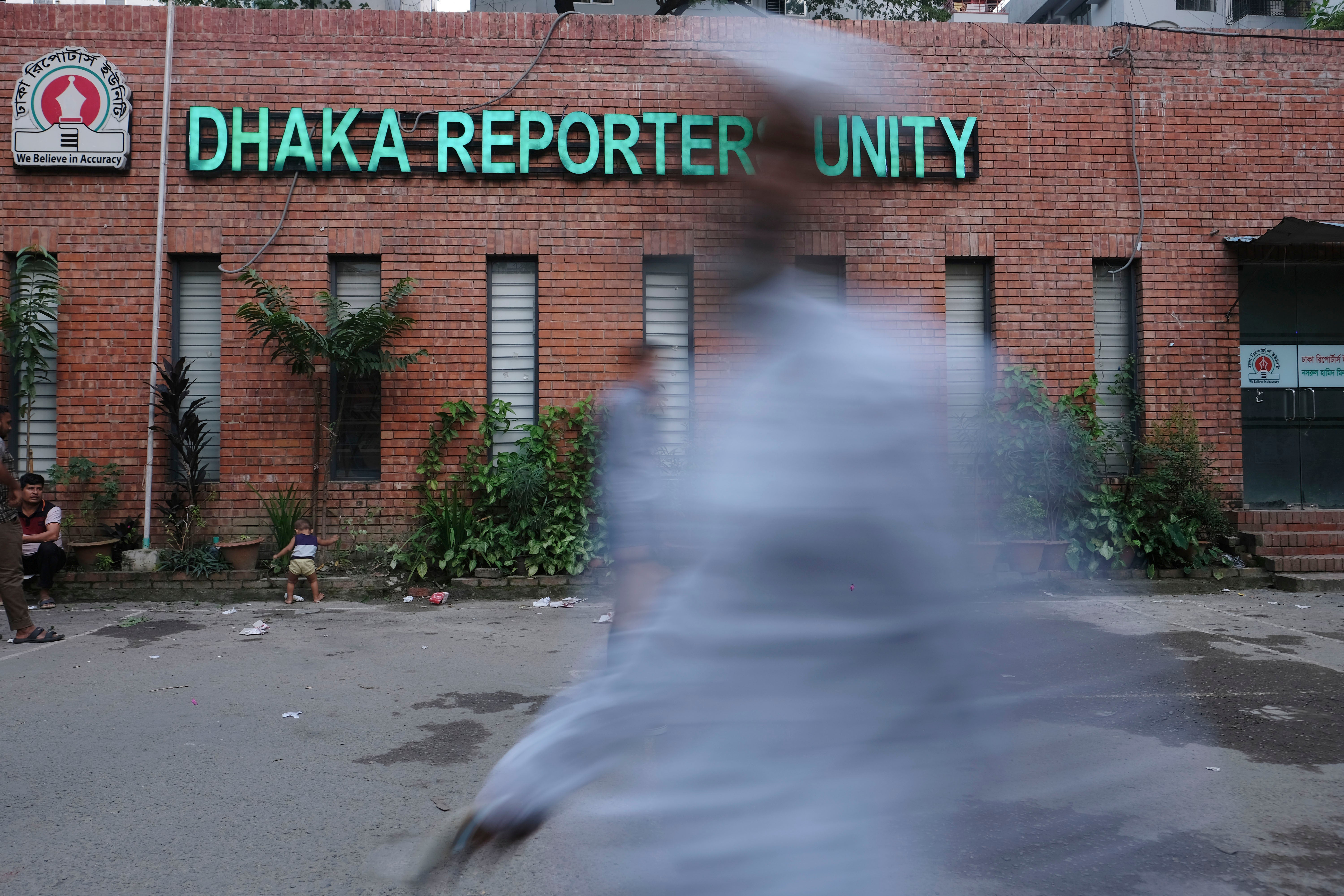 Commuters walk past Dhaka Reporters Unity building where journalists and professionals meet, in Dhaka, Bangladesh