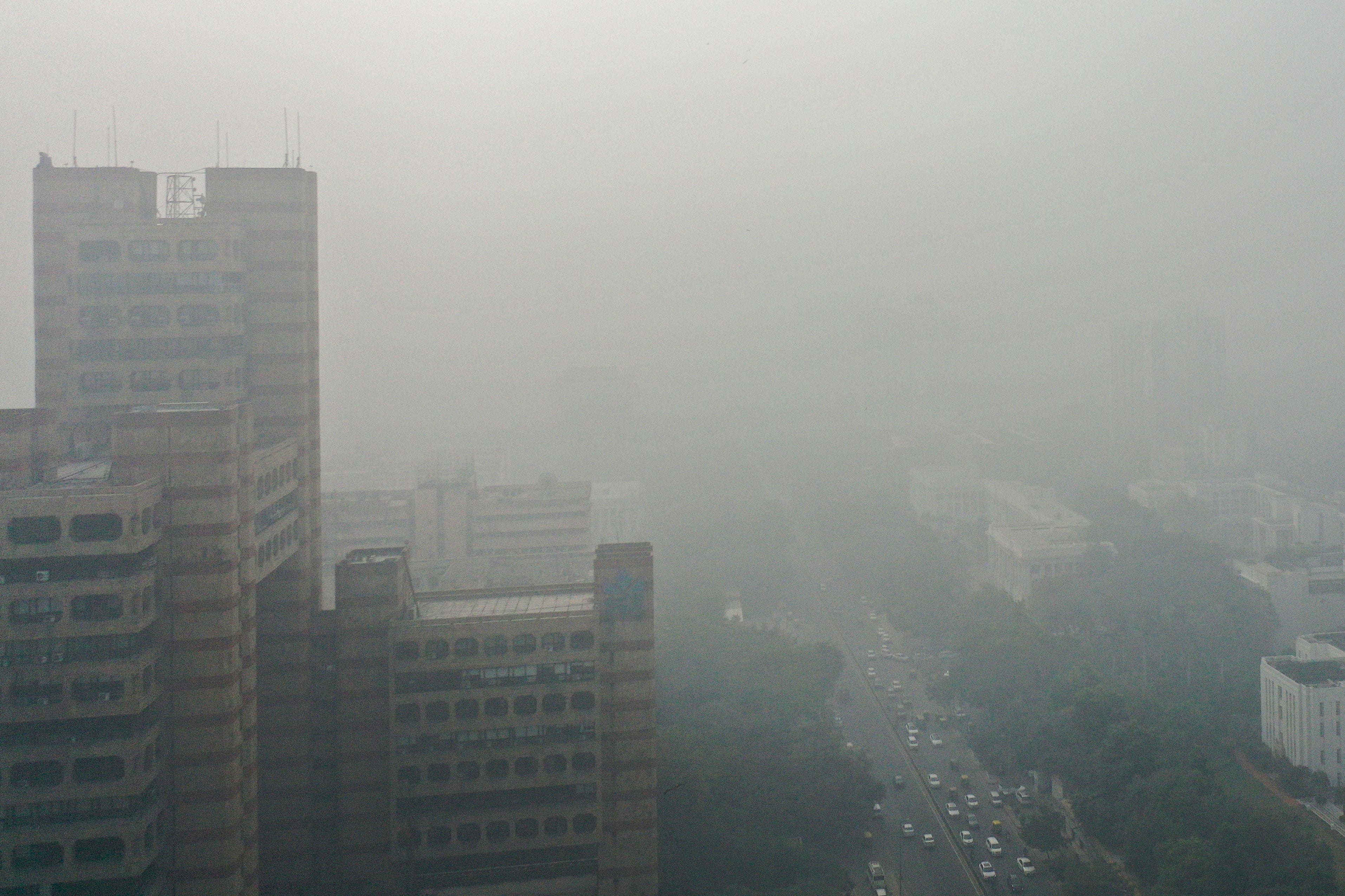 An aerial view shows cars along a road engulfed in smog in New Delhi