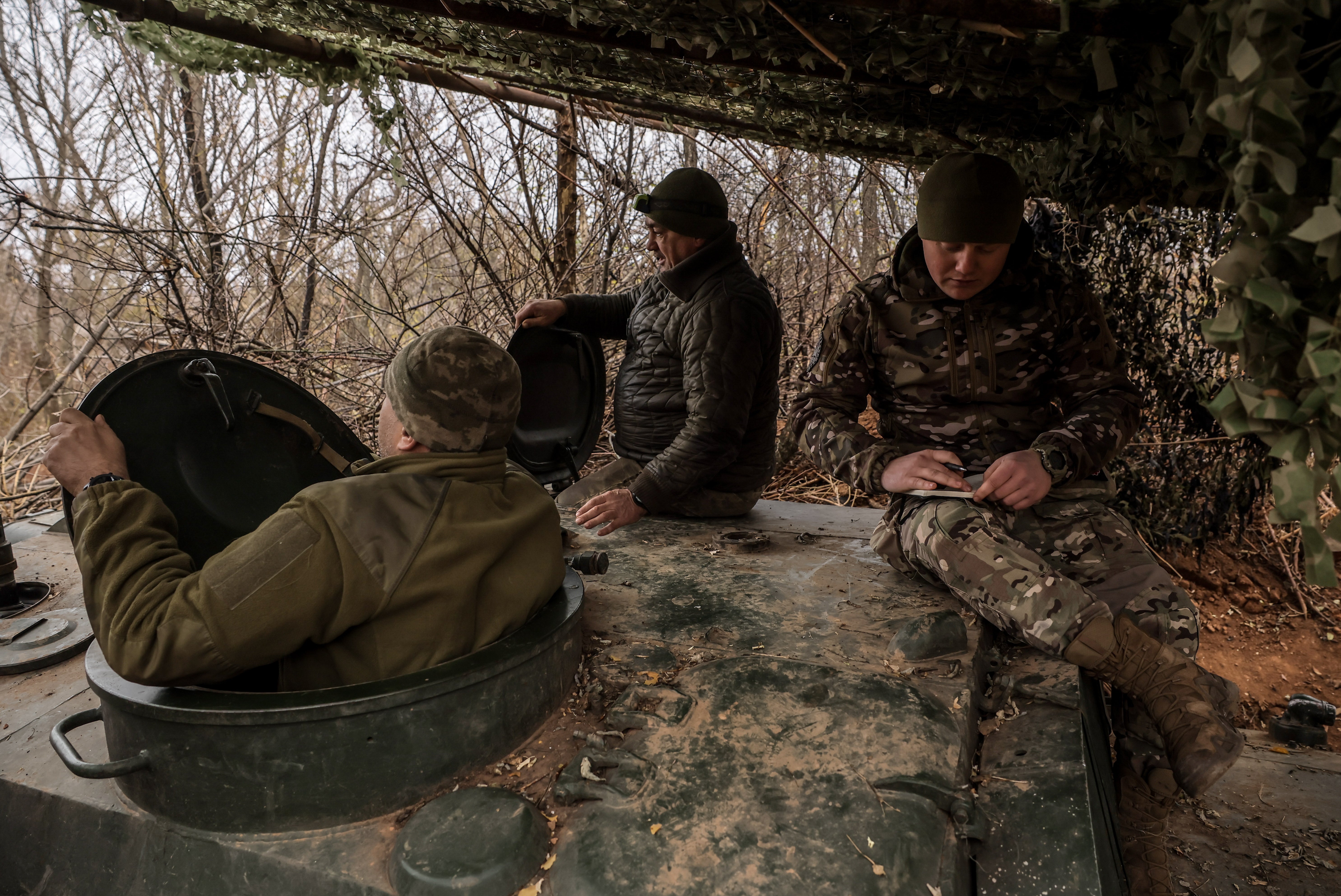 Ukrainian soldiers from the artillery unit of the 24th Mechanised Brigade sit at their position near Chasiv Yar, Donetsk region