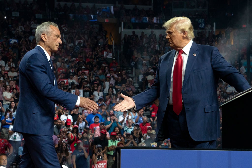 Robert F. Kennedy Jr. and Donald Trump shake hands during a campaign rally at Desert Diamond Arena on August 23, 2024 in Glendale, Arizona. Anti-abortion advocates are pushing back on his nomination for HHS Secretary — but pro-abortion advocates are too