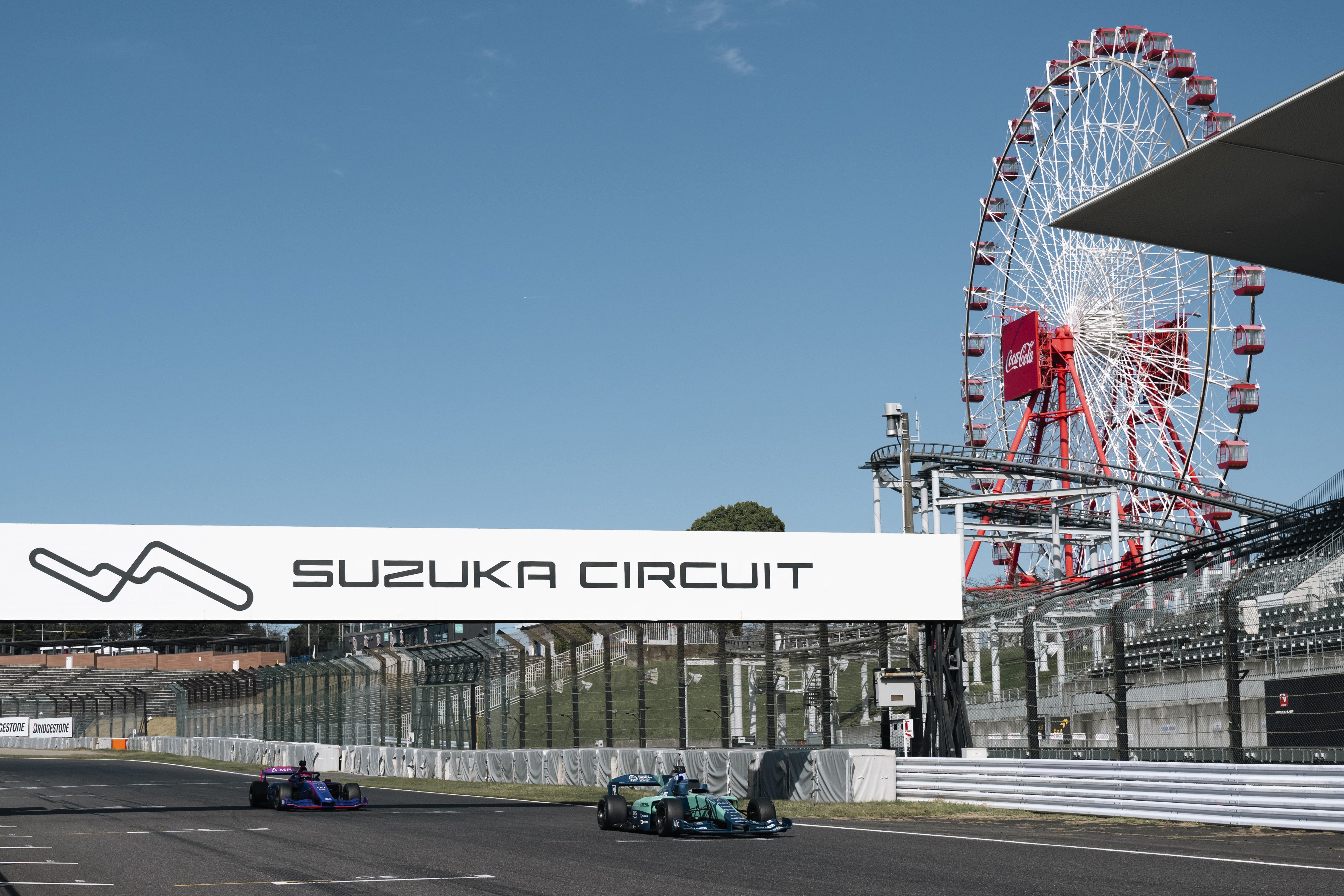 An autonomous Super Formula car (R) lines up ahead of a Super Formula car driven by Daniil Kvyat on the grid of the Suzuka Circuit, Japan, on 10 November, 2024