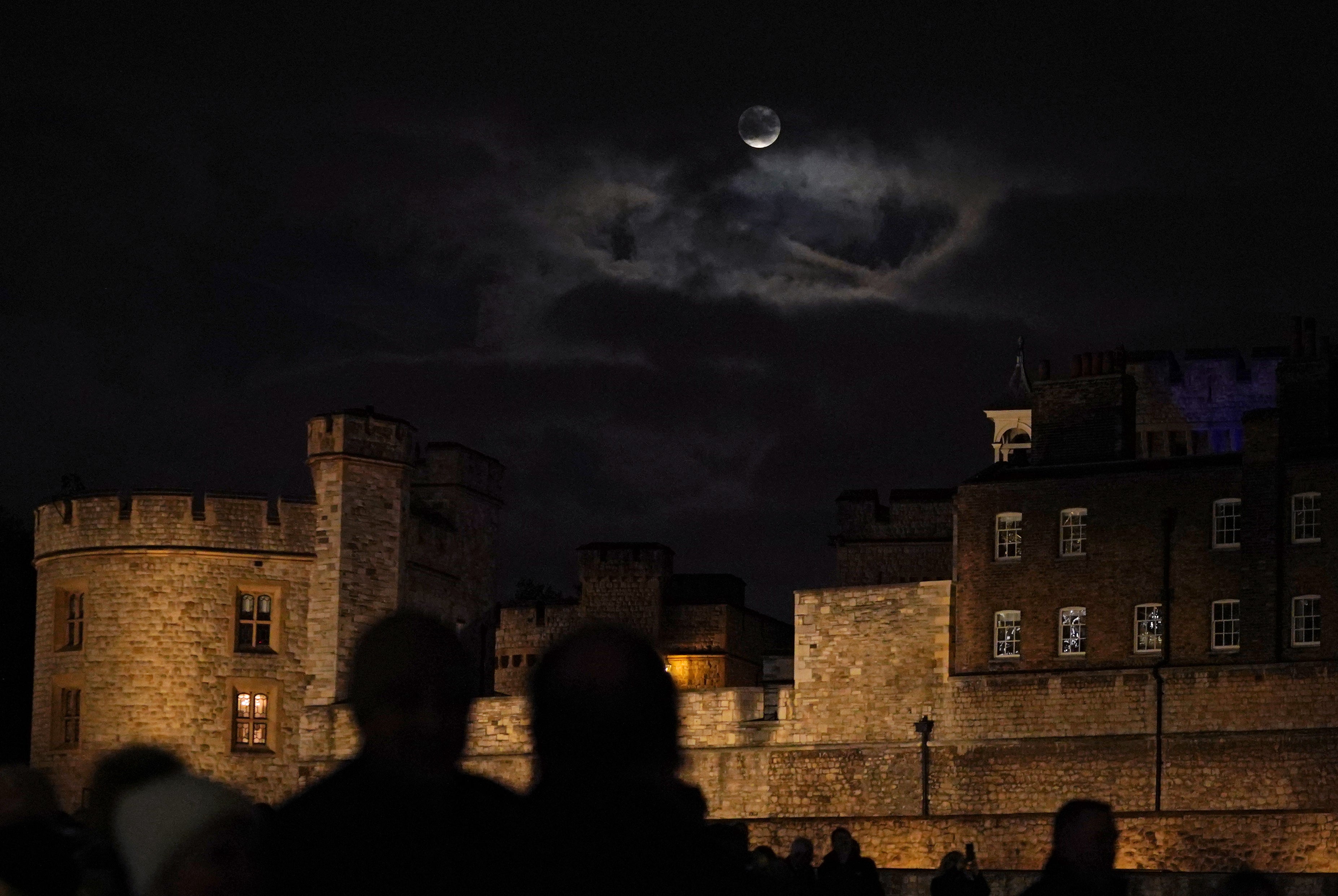 A glimpse of the Beaver Moon through clouds over the Tower of London