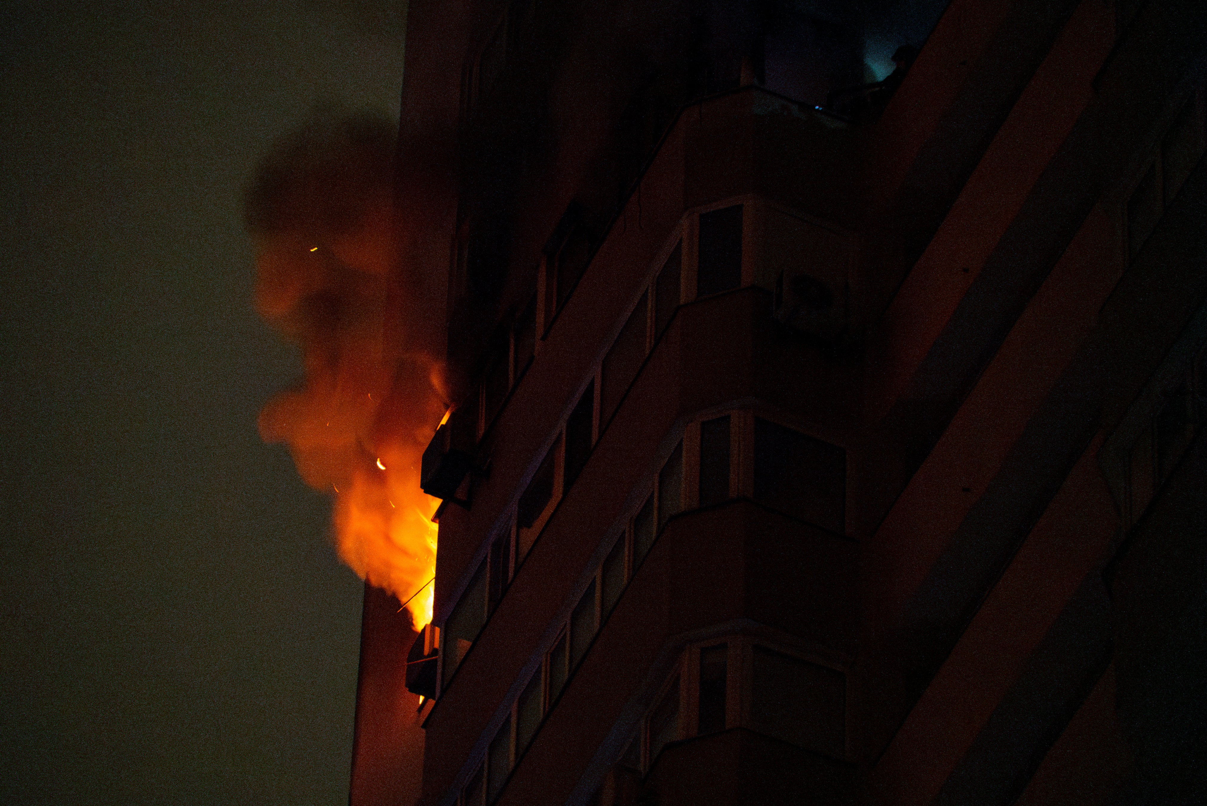 Flames and smoke rise from a residential building after an attack on Kyiv by Russian drones