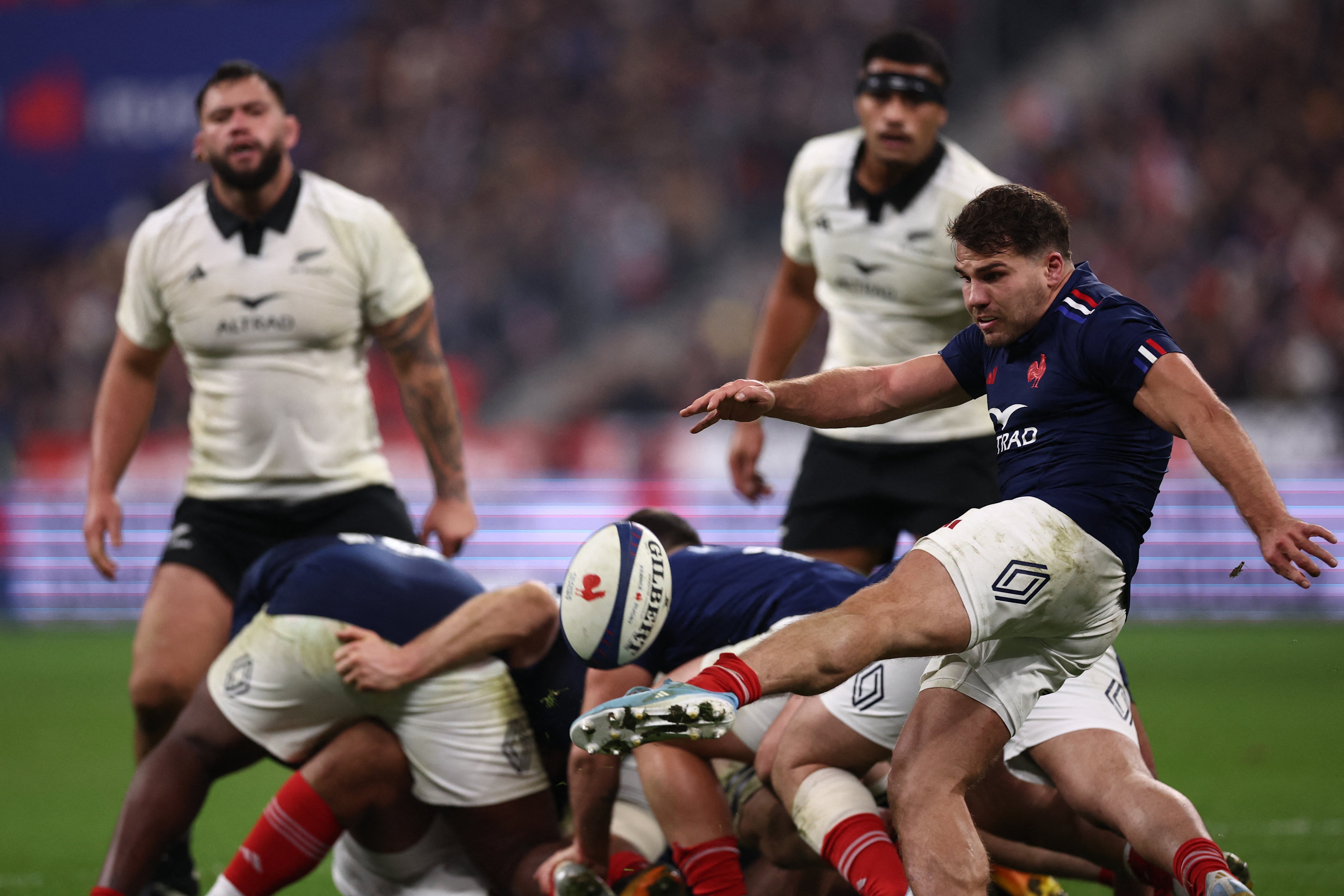 France's scrum-half and captain Antoine Dupont (R) clears the ball