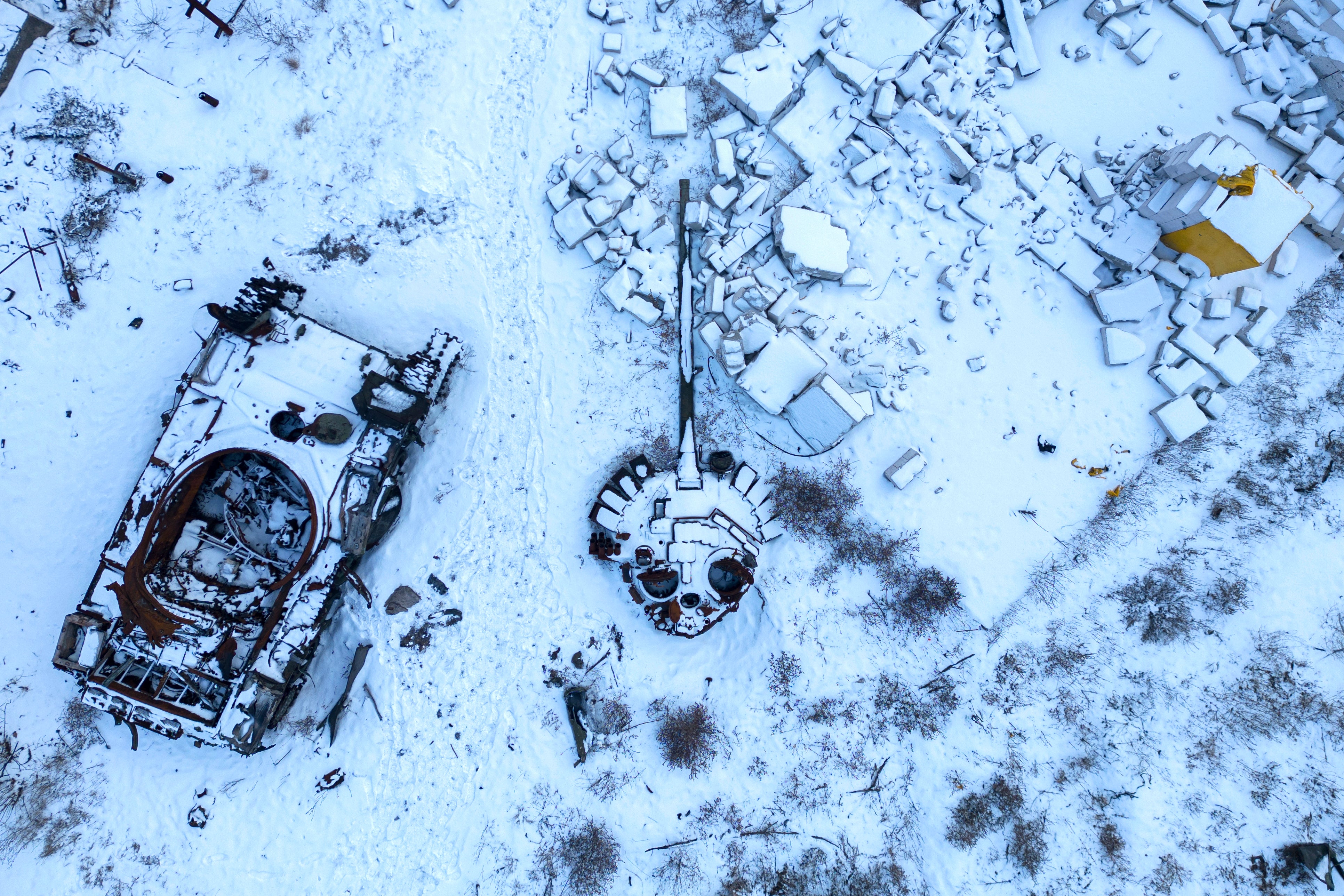 A destroyed Russian tank, covered in snow, stands in the yard of a private house in the town of Sviatohirsk