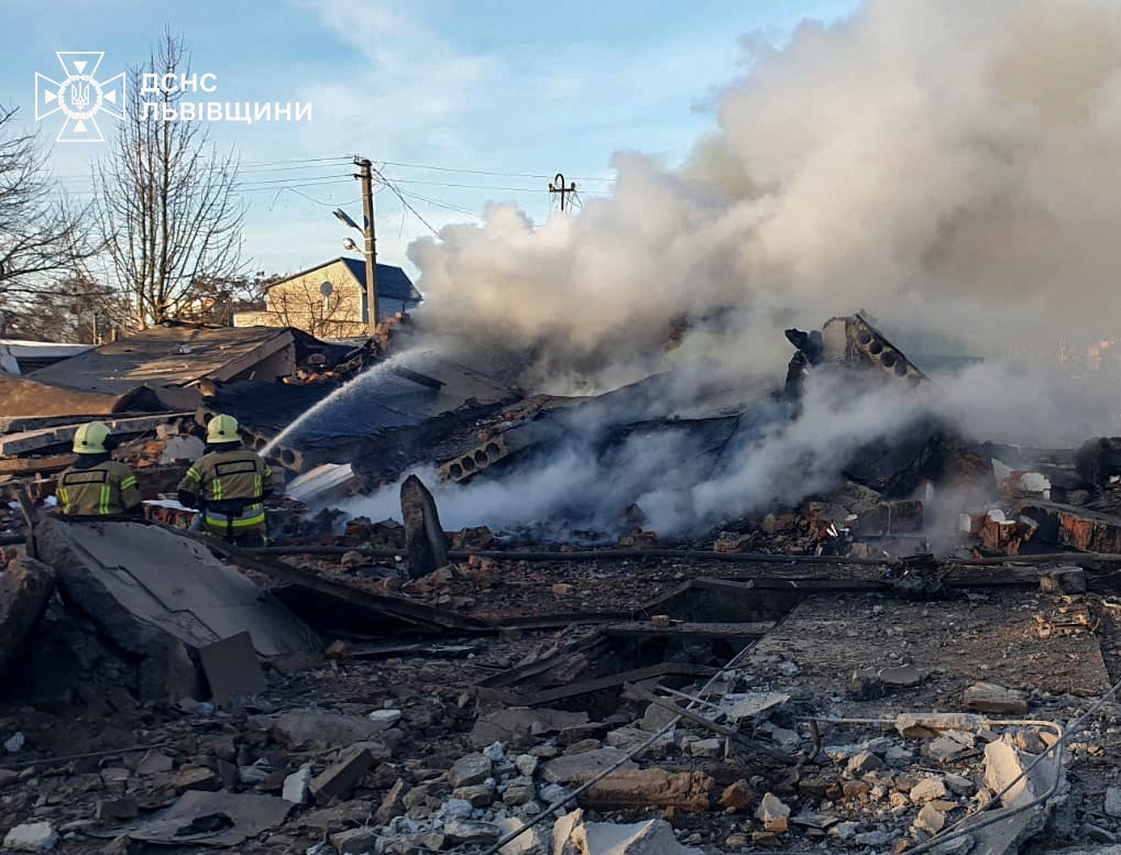 Firefighters work at the site of residential area hit by a Russian missile strike, amid Russia's attack on Ukraine, in Lviv region